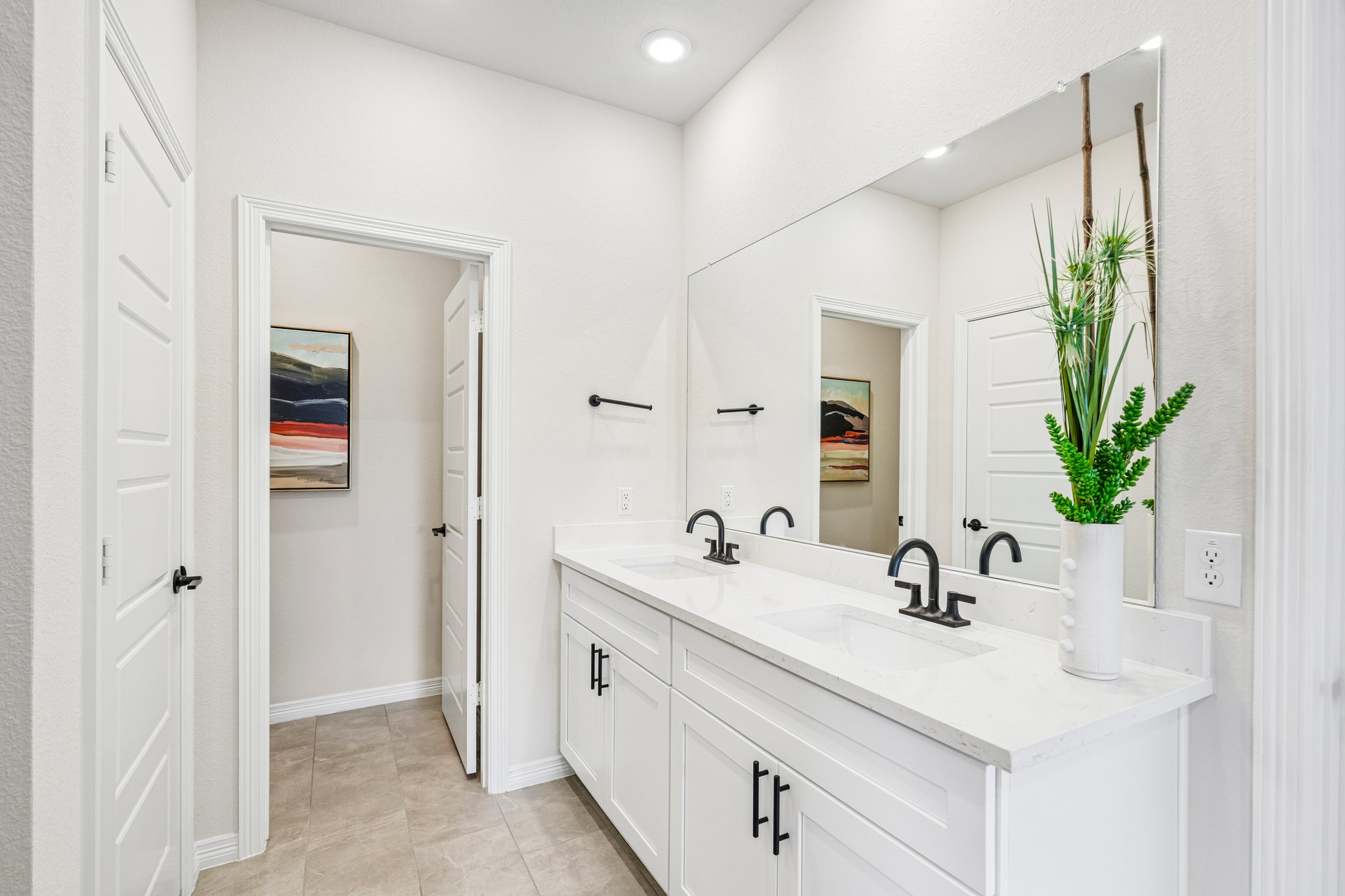 A bathroom with white cabinets.