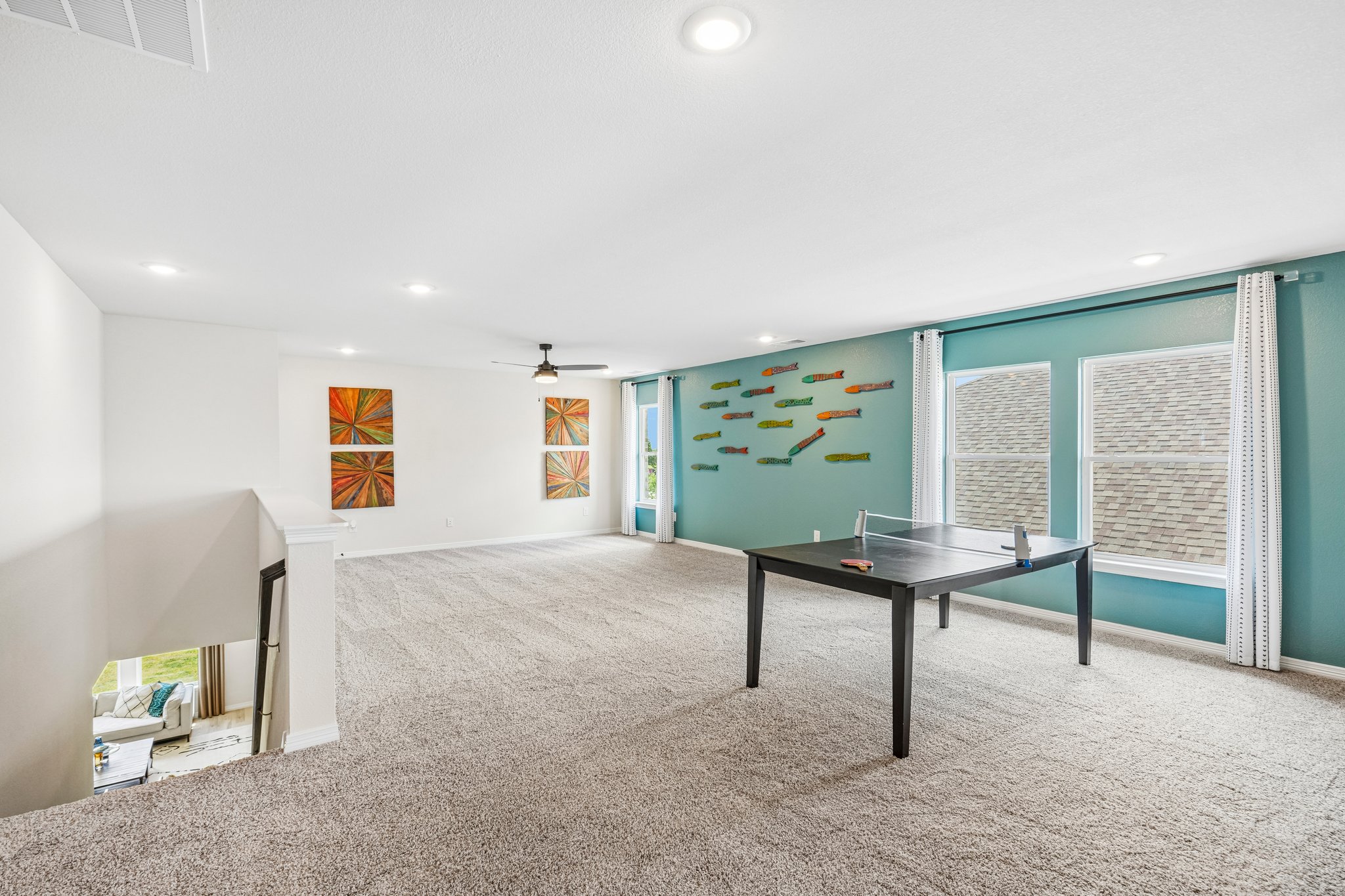 A room with a table and a wall with art on it.