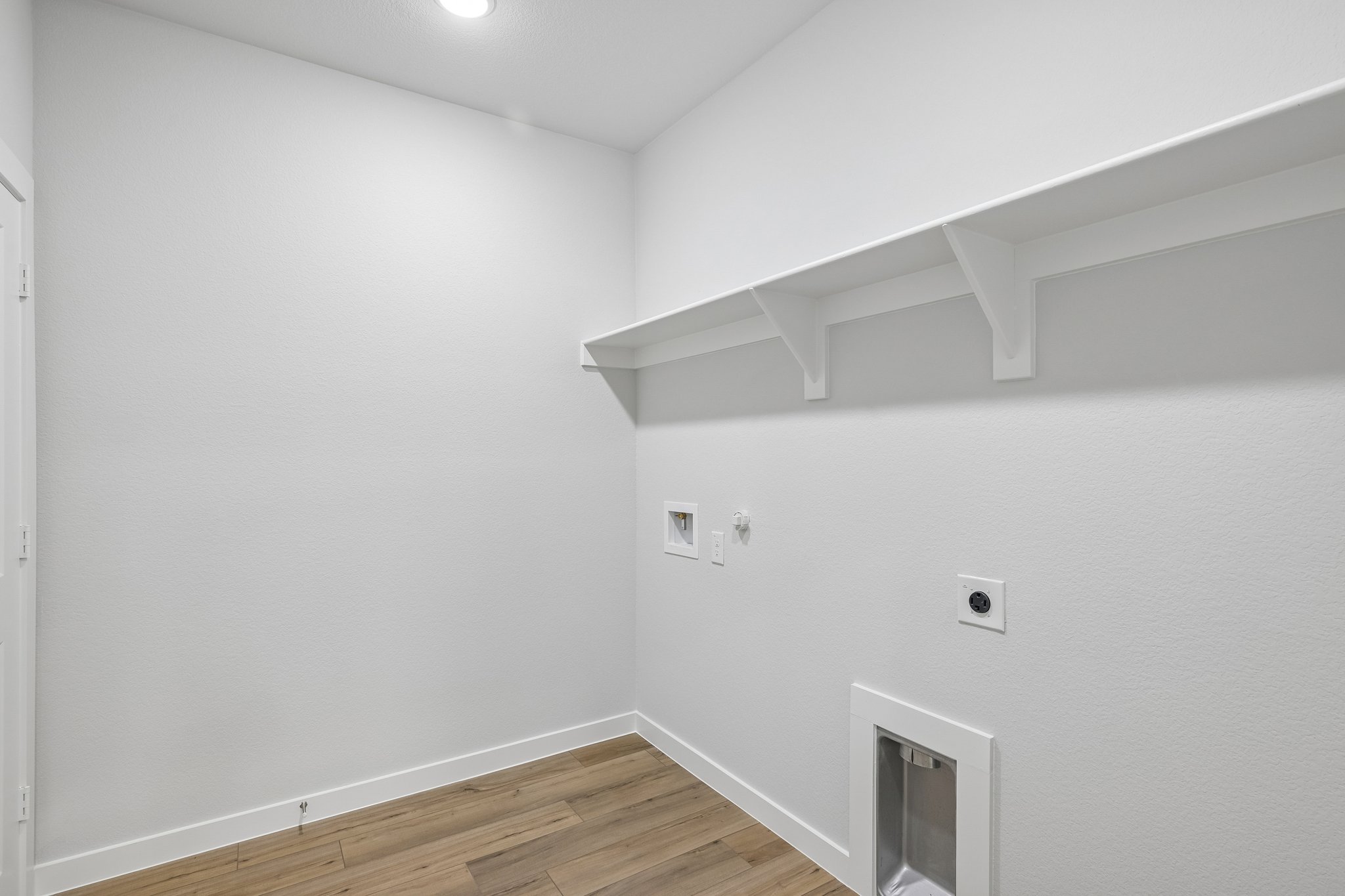 A white room with a wood floor.