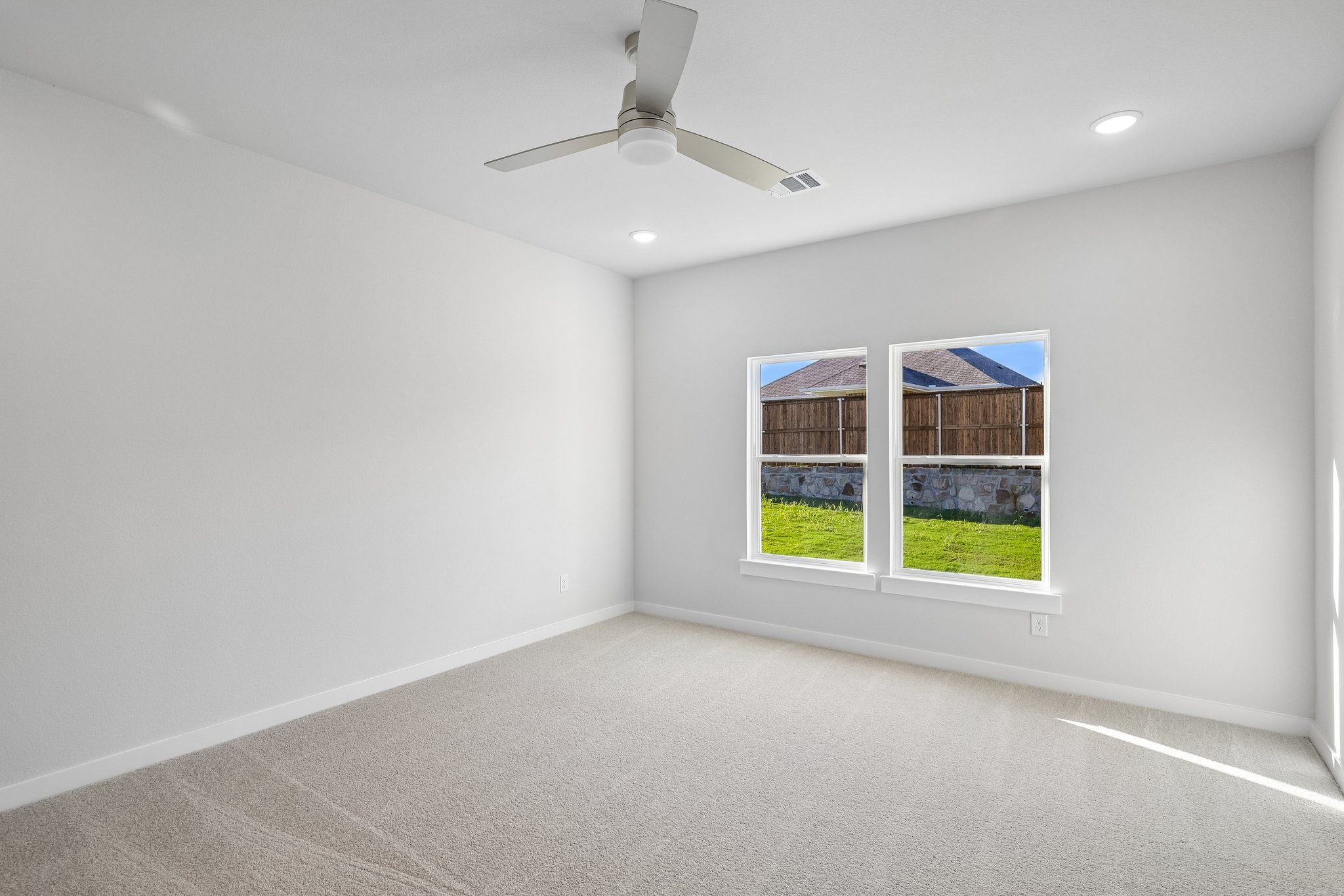 A room with a ceiling fan and a window.