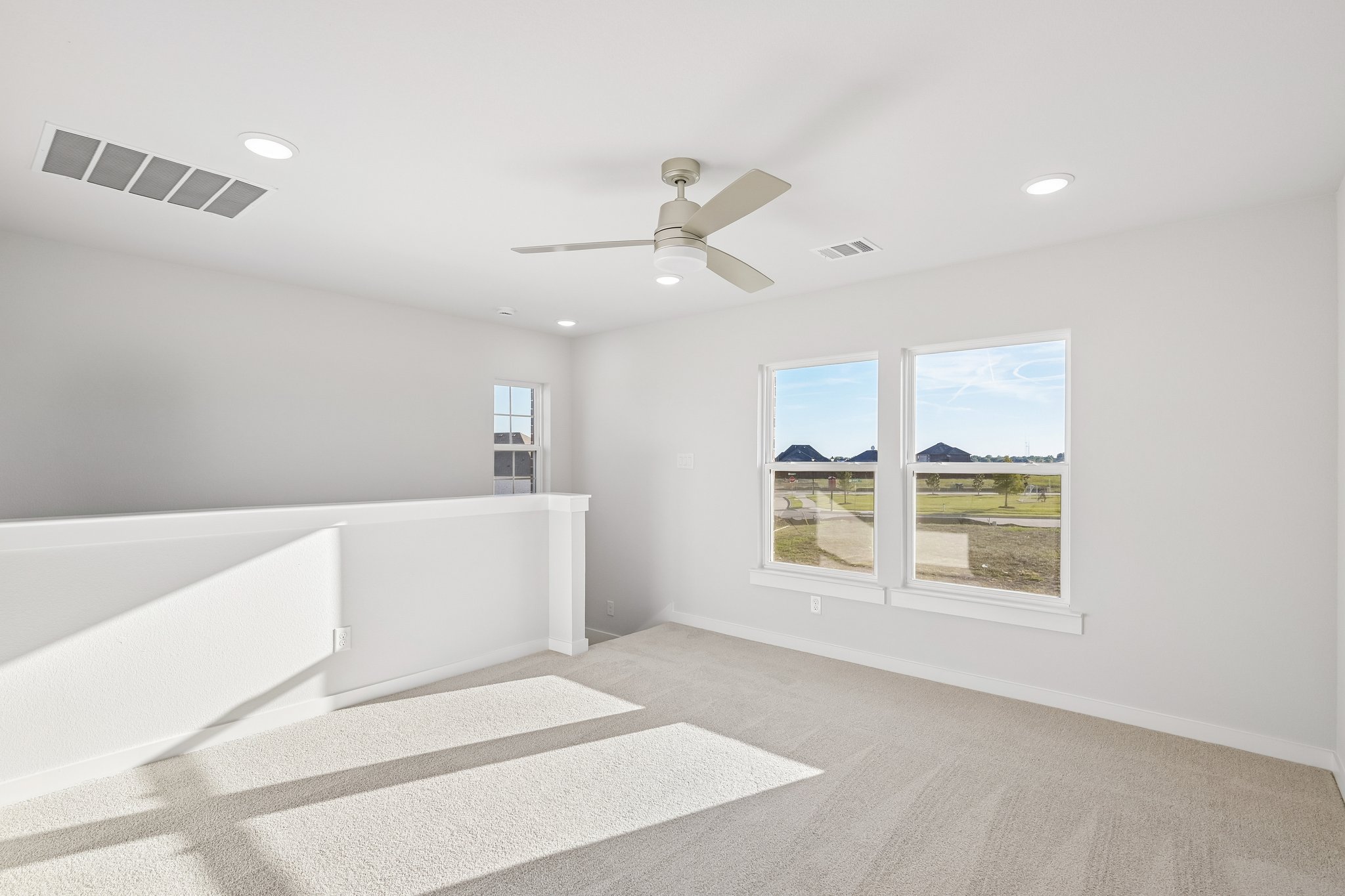 A room with a large window and a large white wall with a view of the city.
