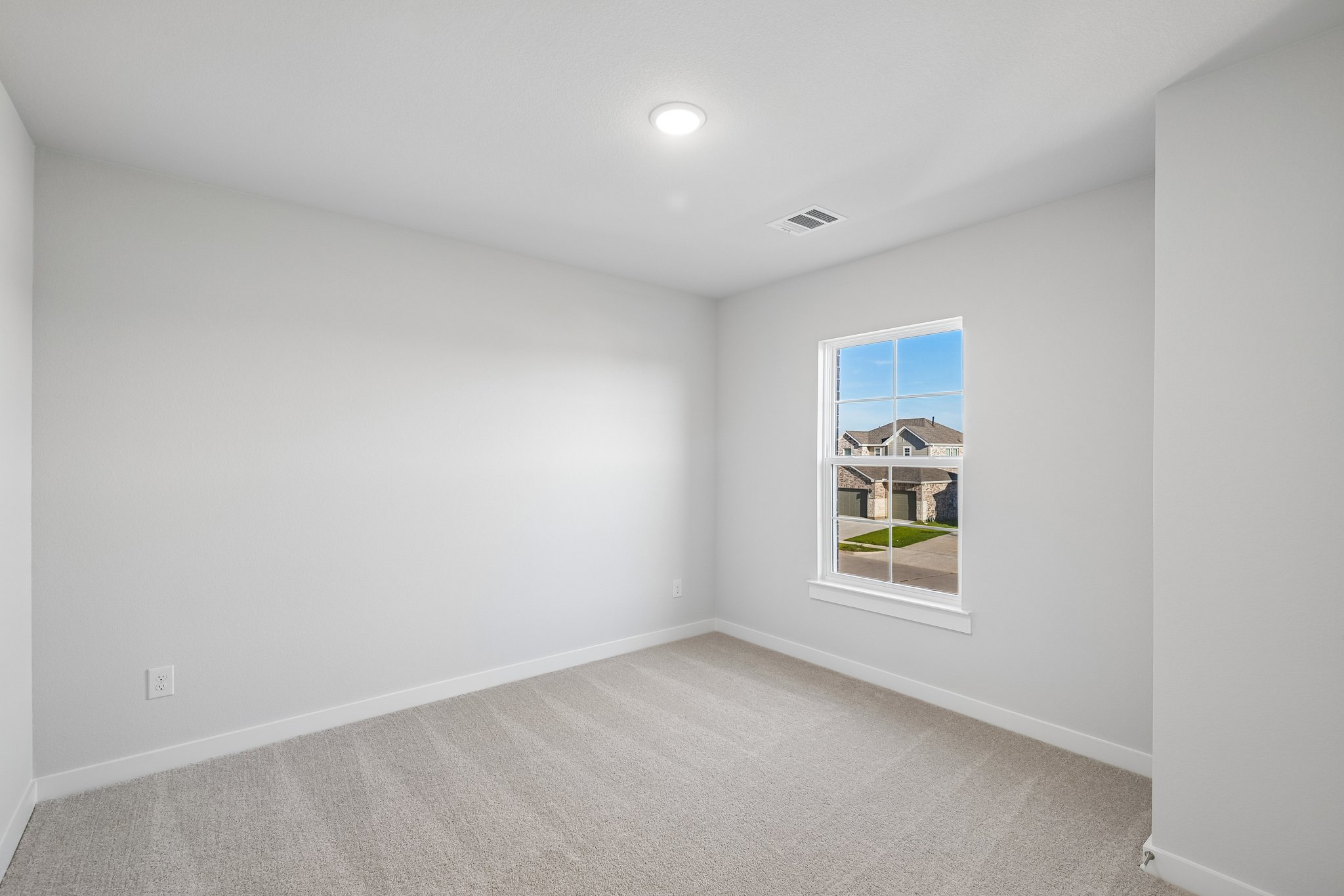 A room with a window and a carpet.