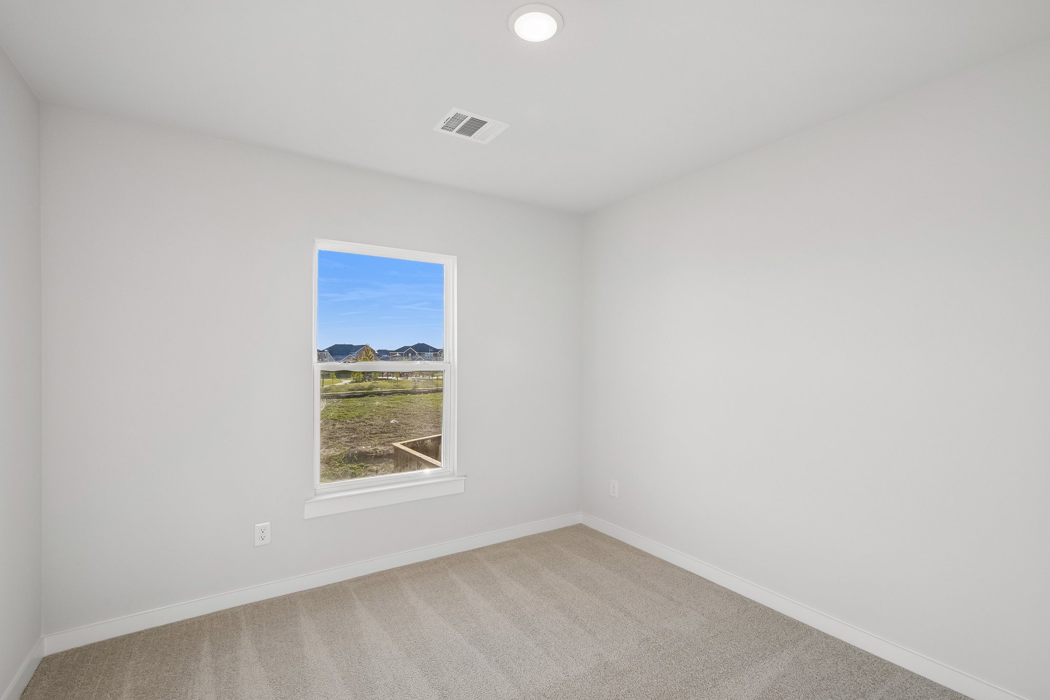 A room with a window and a carpet.