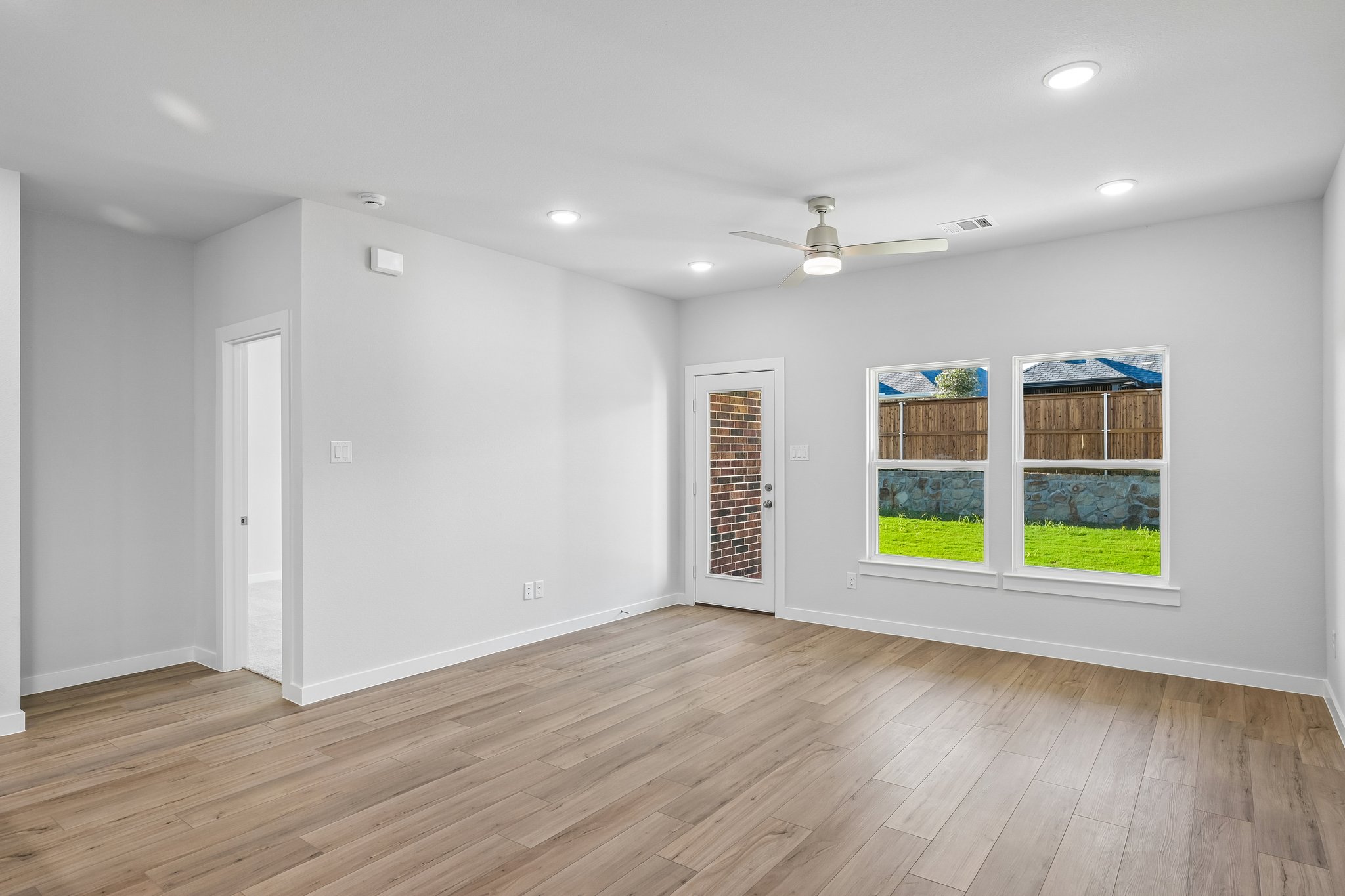 A room with a wood floor and a wood floor with a window.