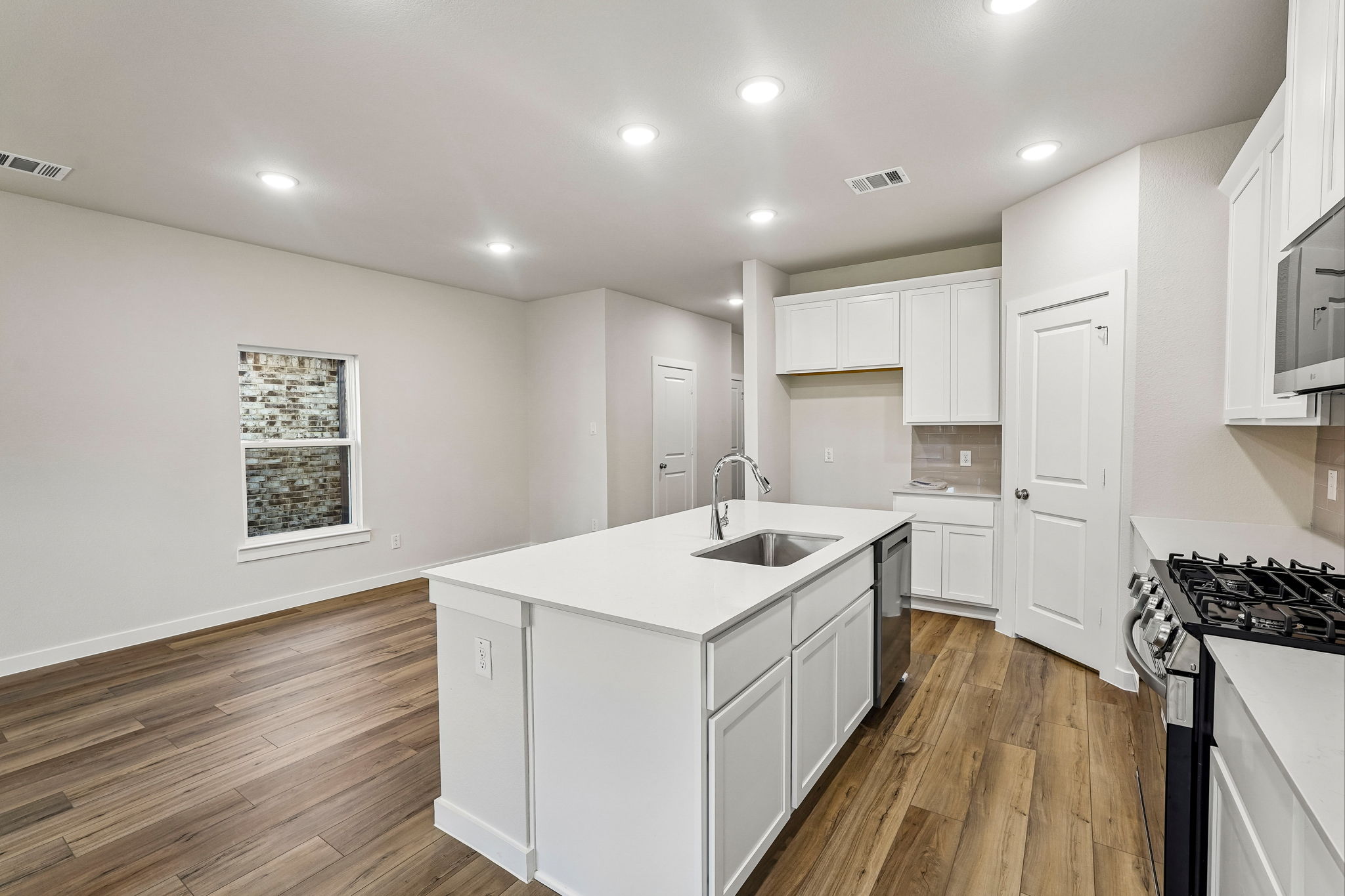 A kitchen with white cabinets.