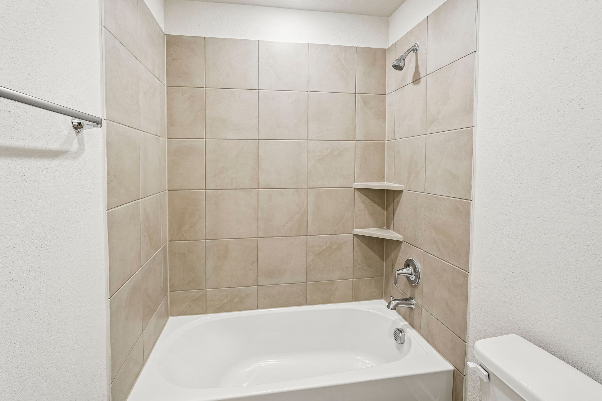 A bathroom with a bathtub and toilet.