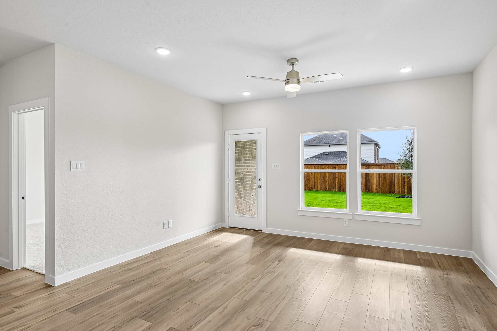 A room with a wood floor and a wood floor with a window.