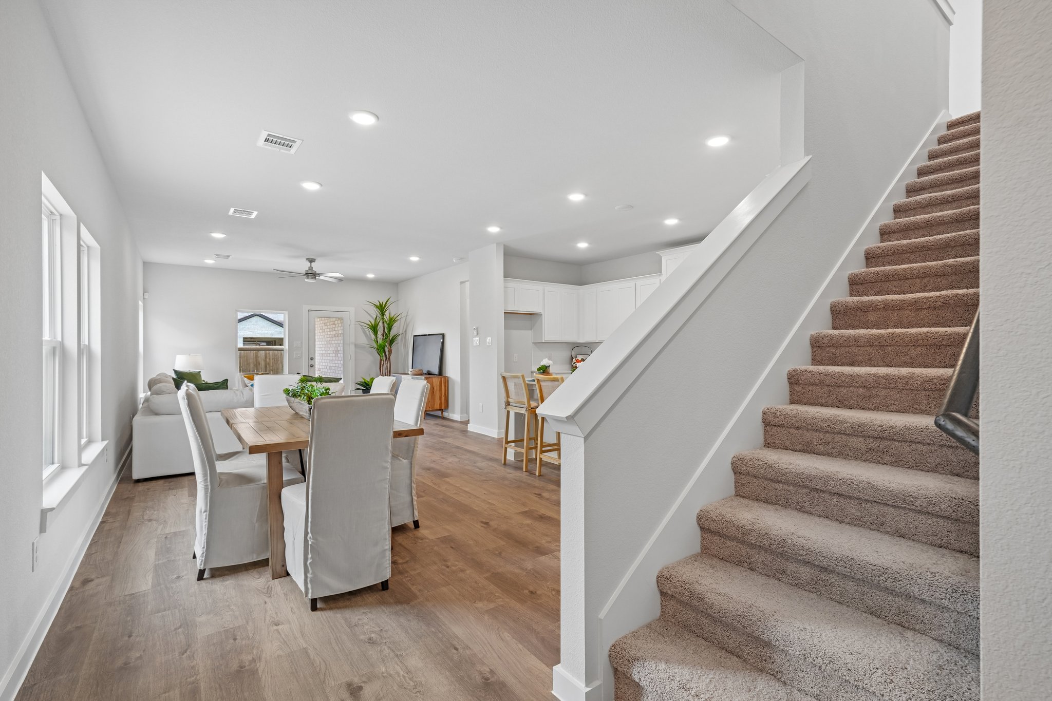 A dining room with a staircase.