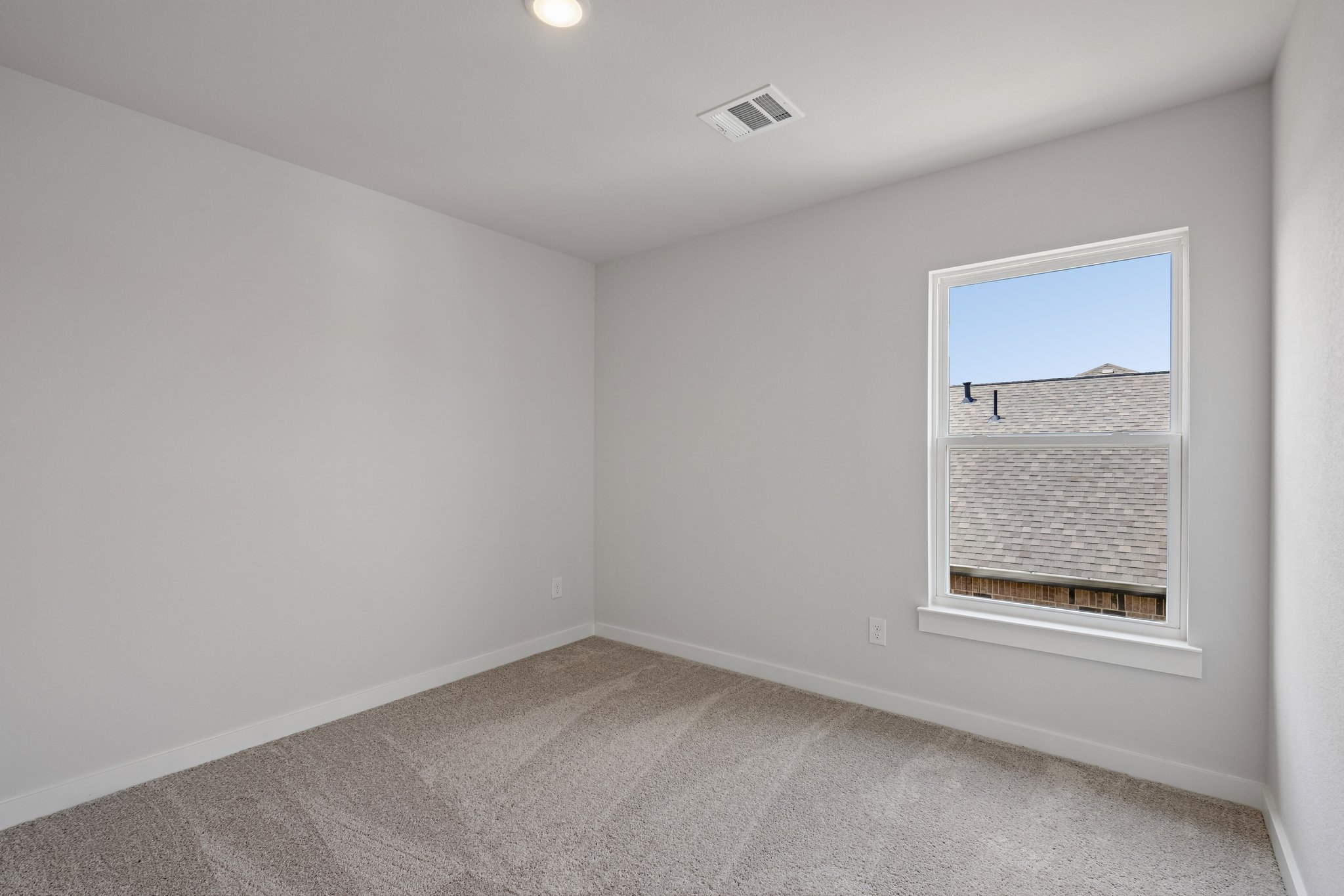 A room with a window and a carpet.