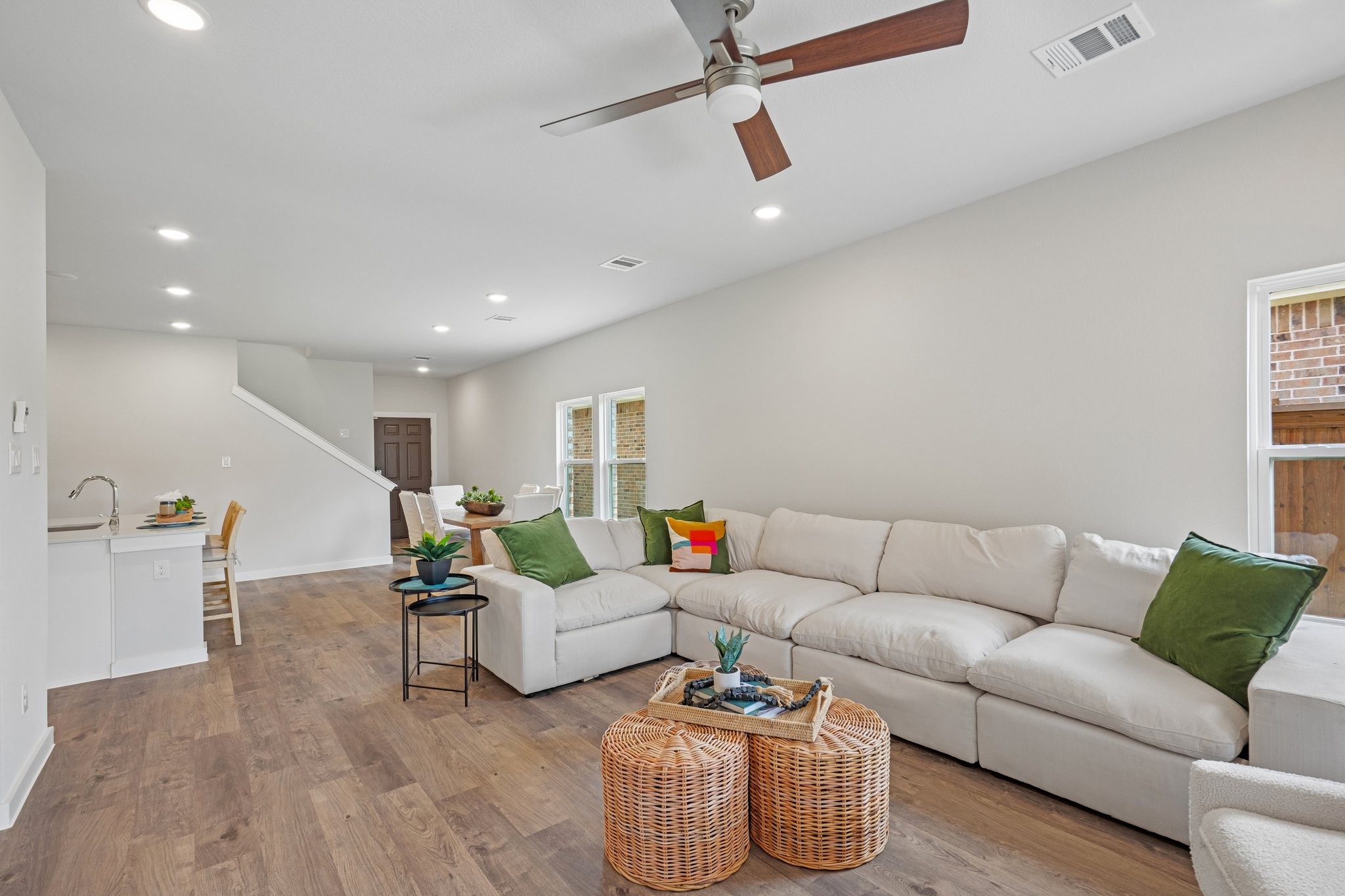 A living room with a white couch and a fan.
