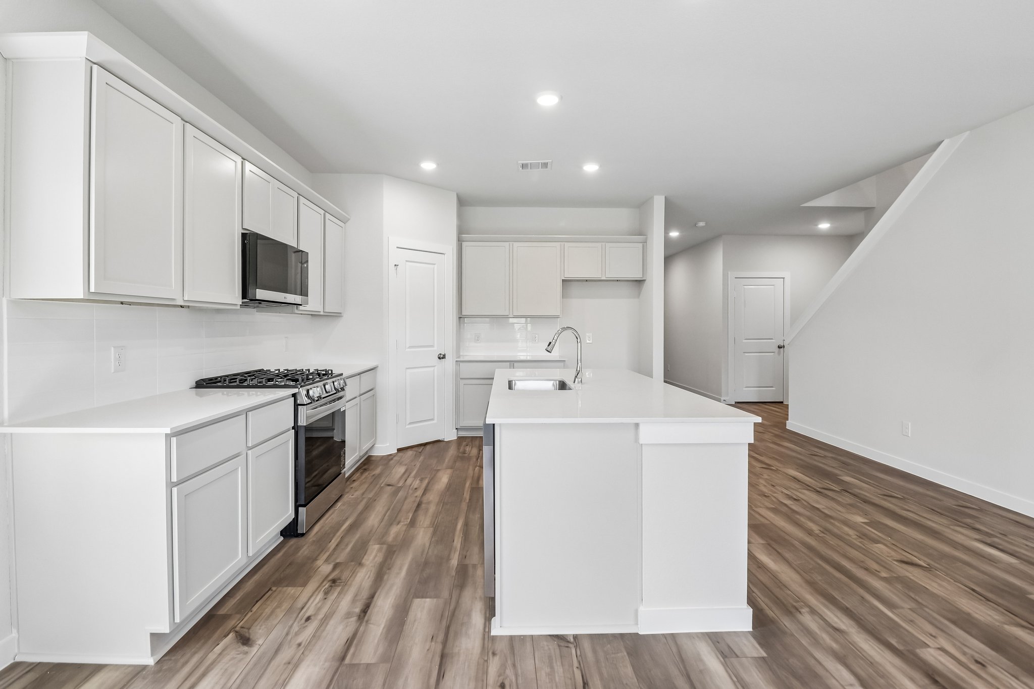 A kitchen with white cabinets.