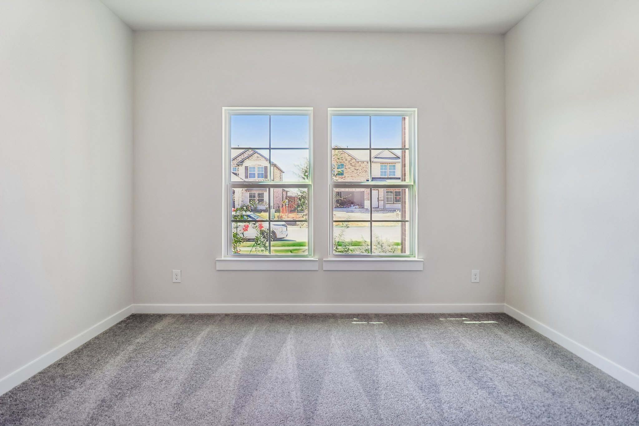 A room with a window and a rug in it.