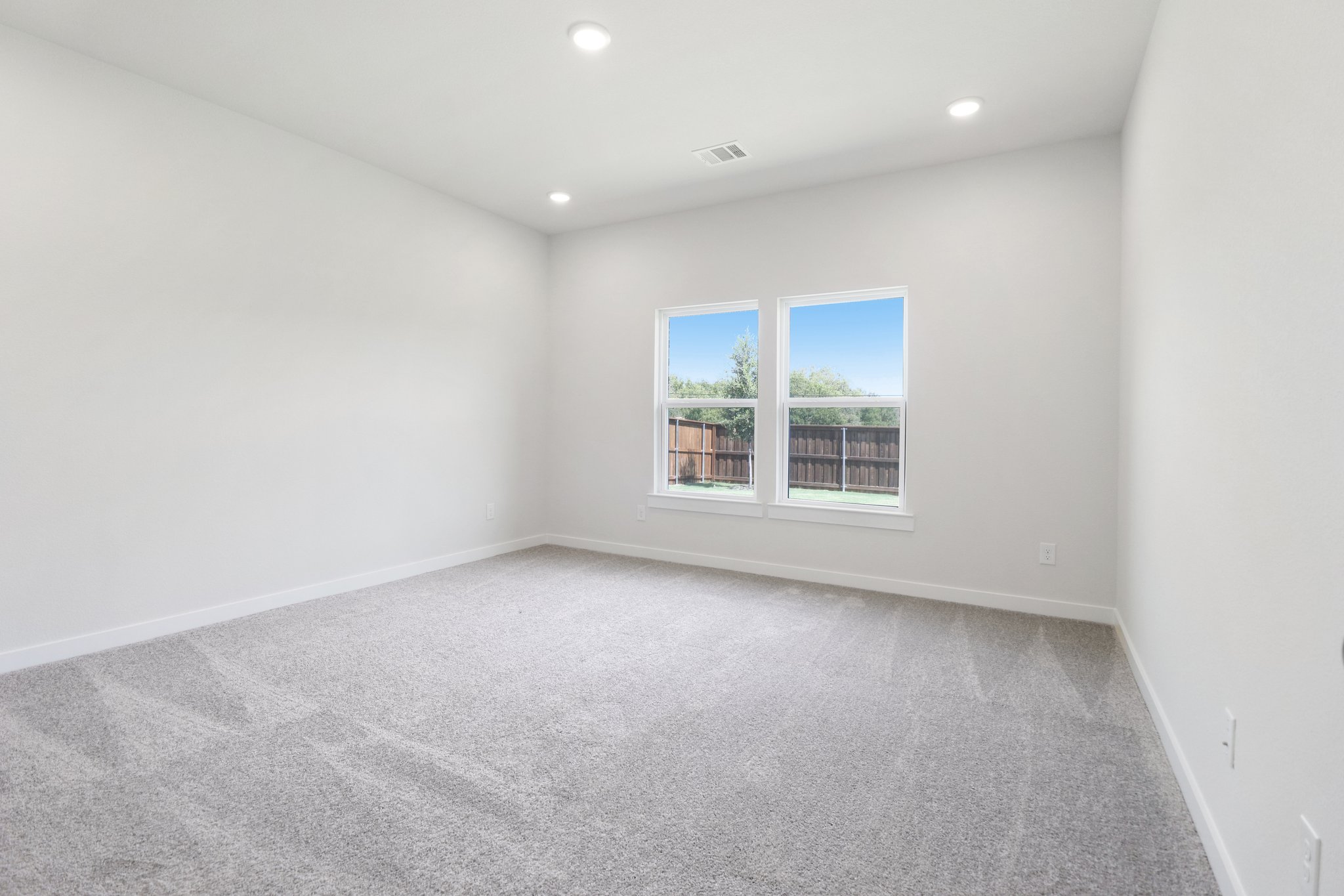 A room with a window and a carpet.
