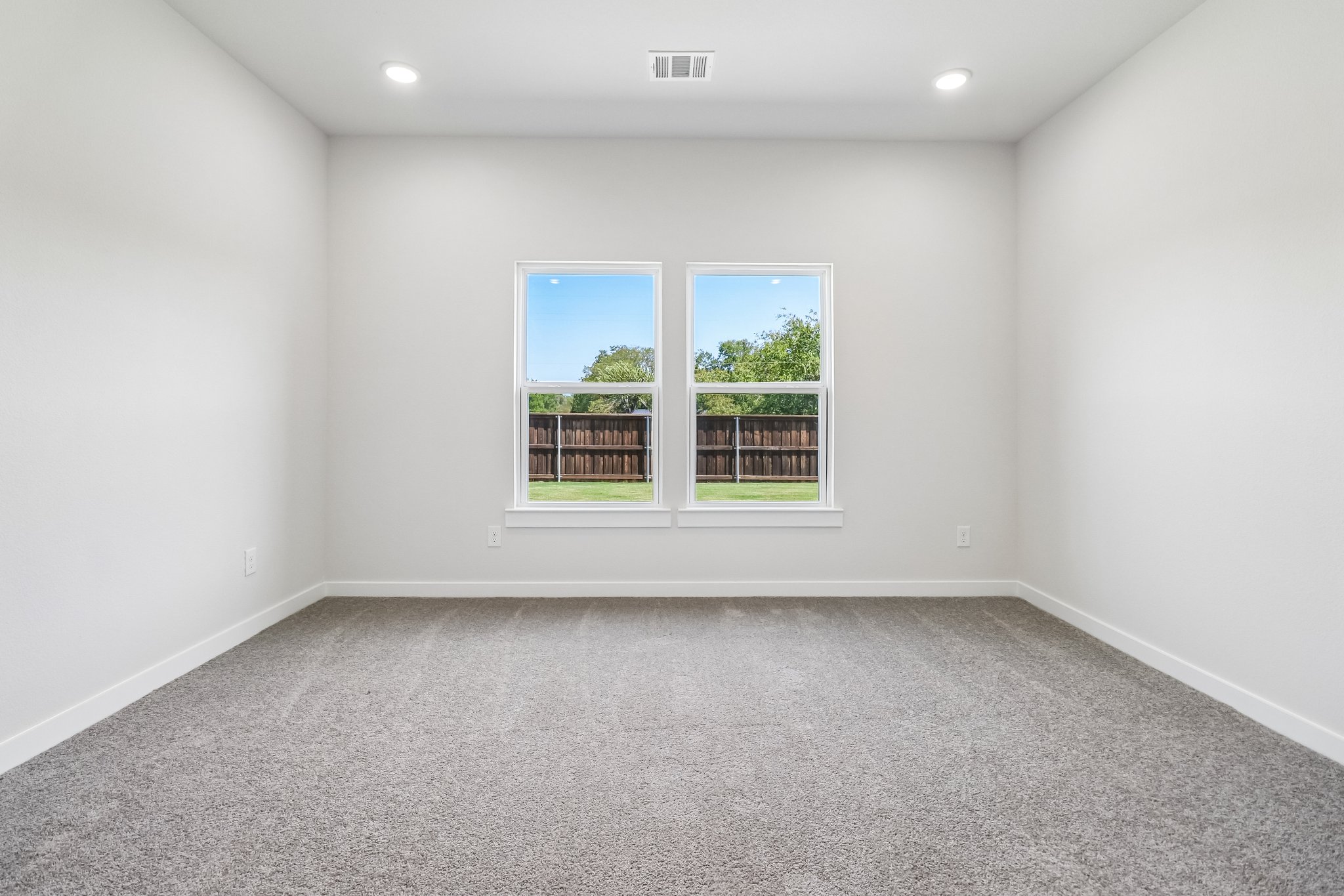 A room with a window and a carpet.