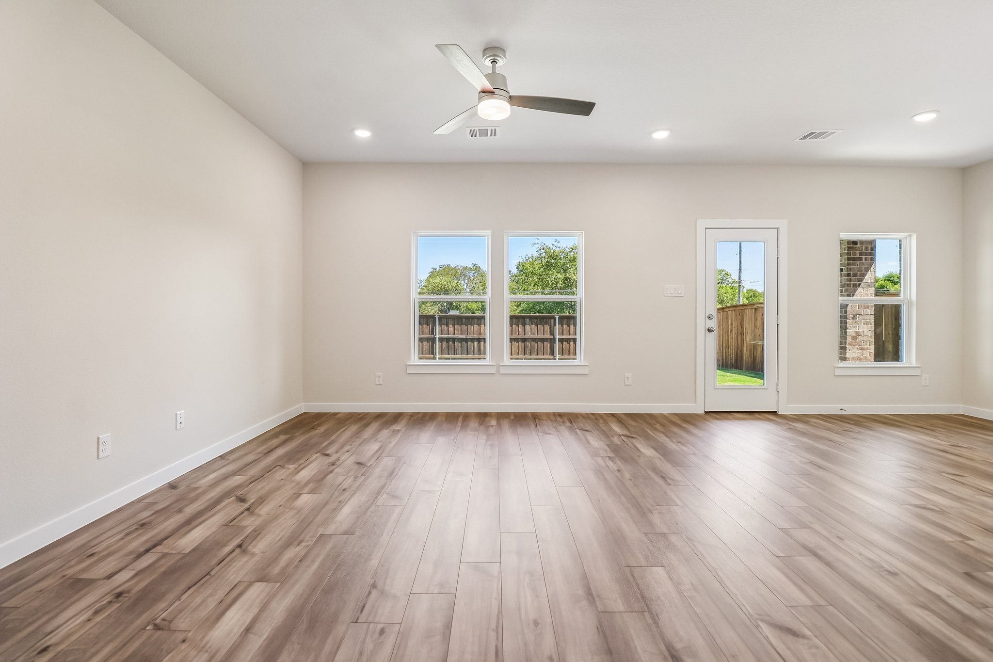 A room with a wood floor and a ceiling fan.