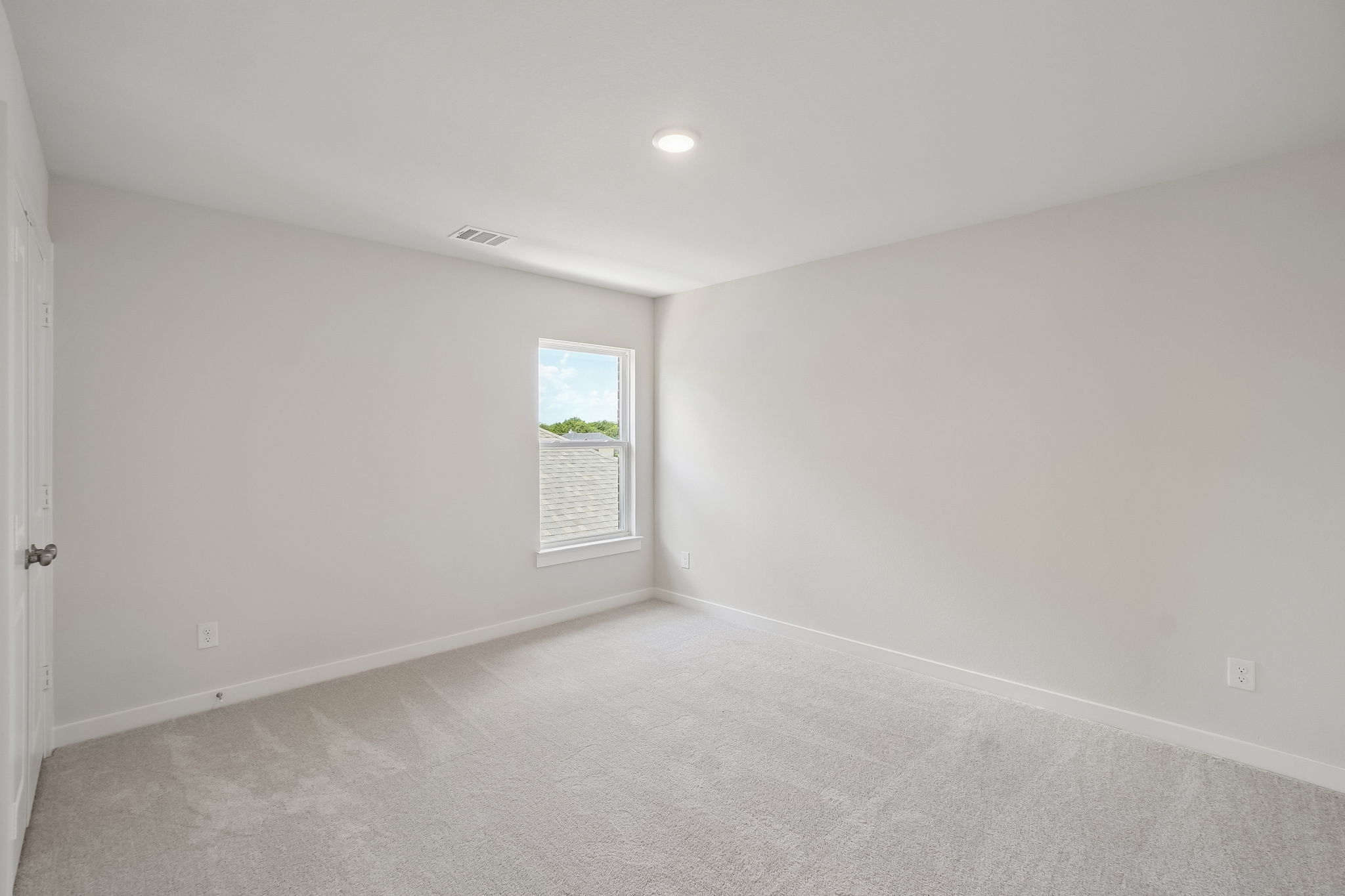 A room with a carpet and a window.