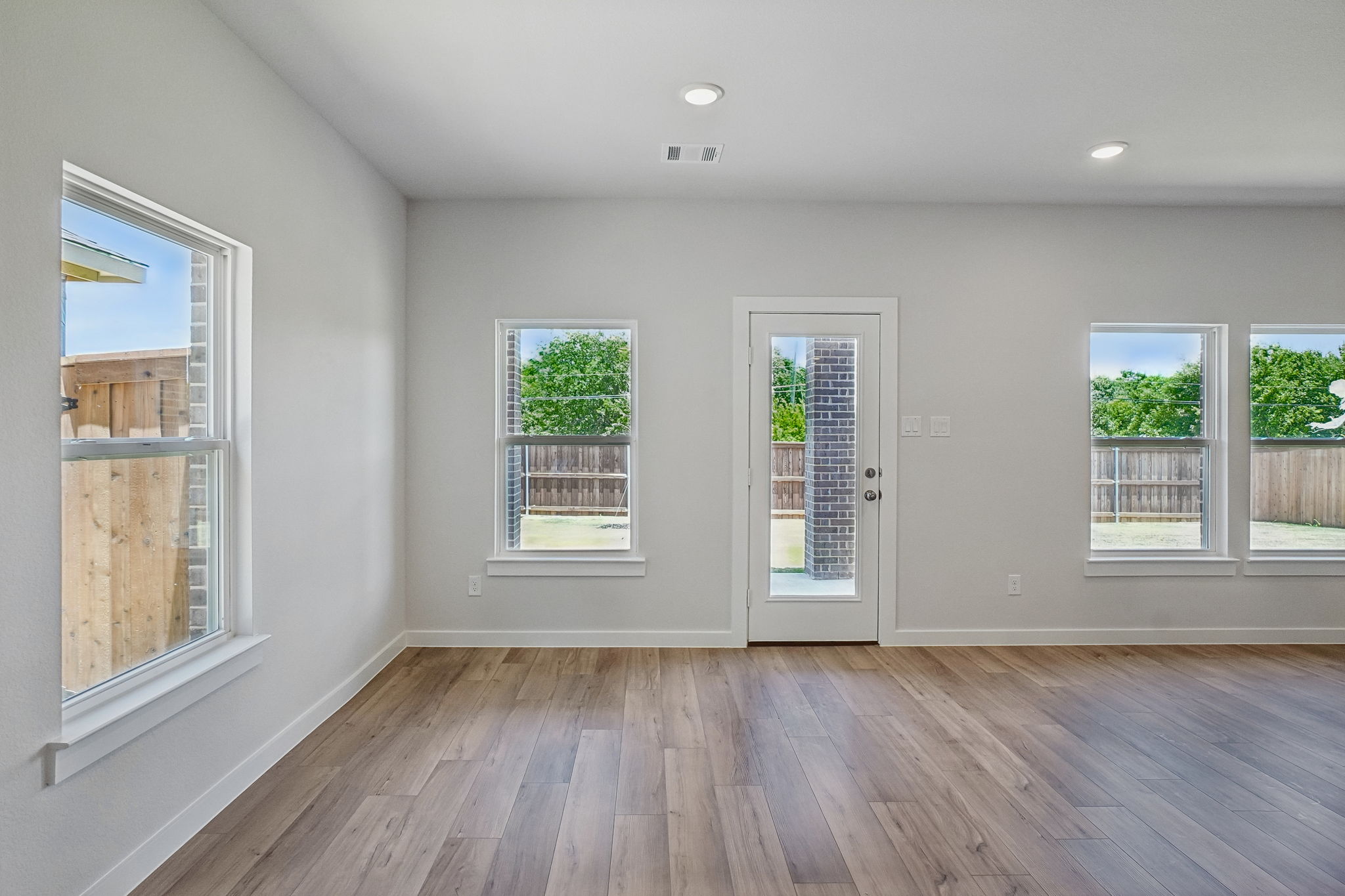 A room with windows and wood floors.