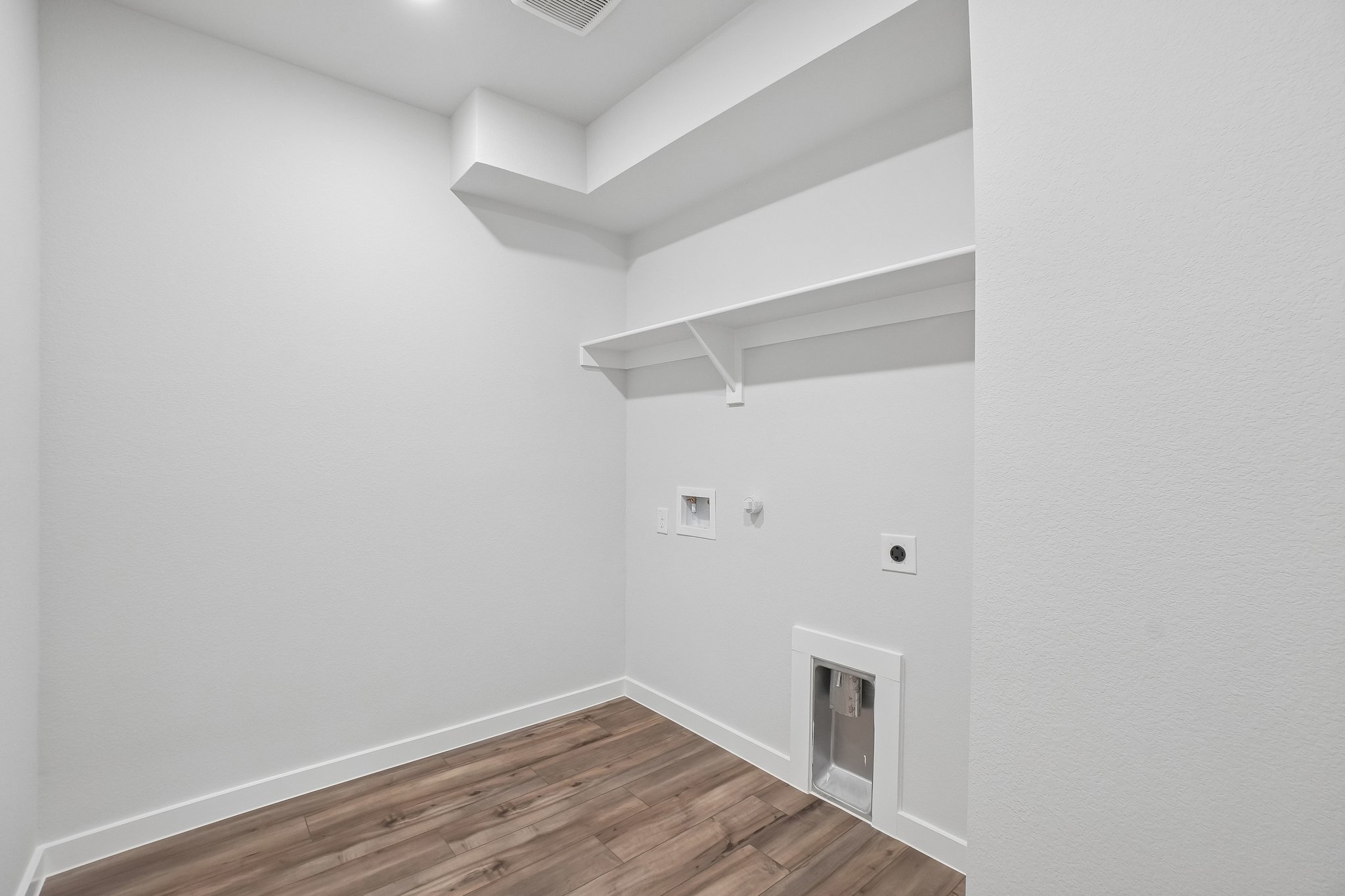 A white room with a wood floor.