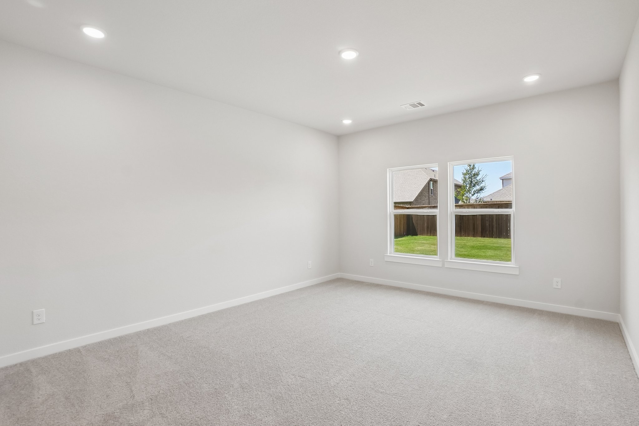 A room with a window and a white wall.