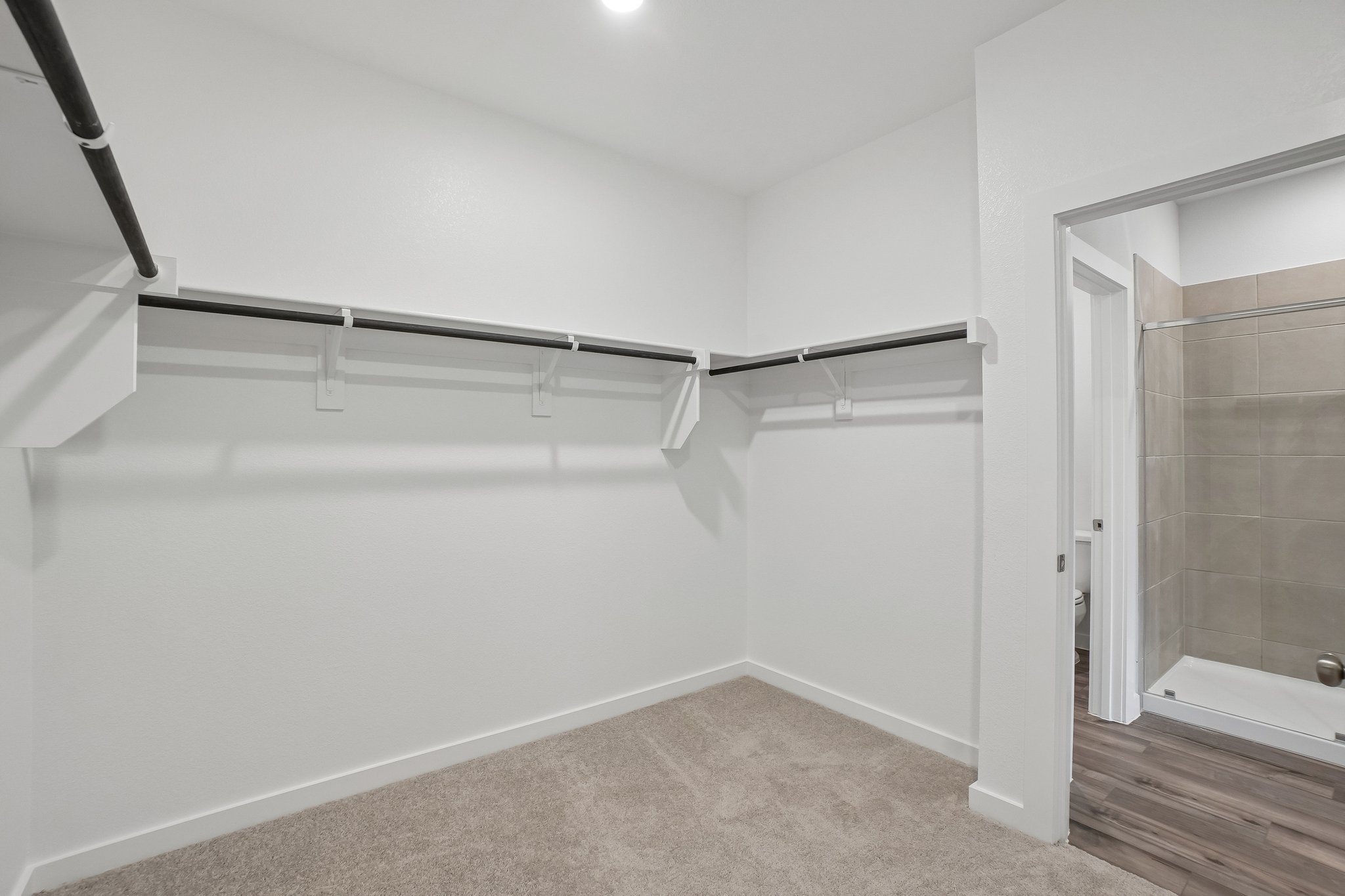 A white room with a shower and a glass door.