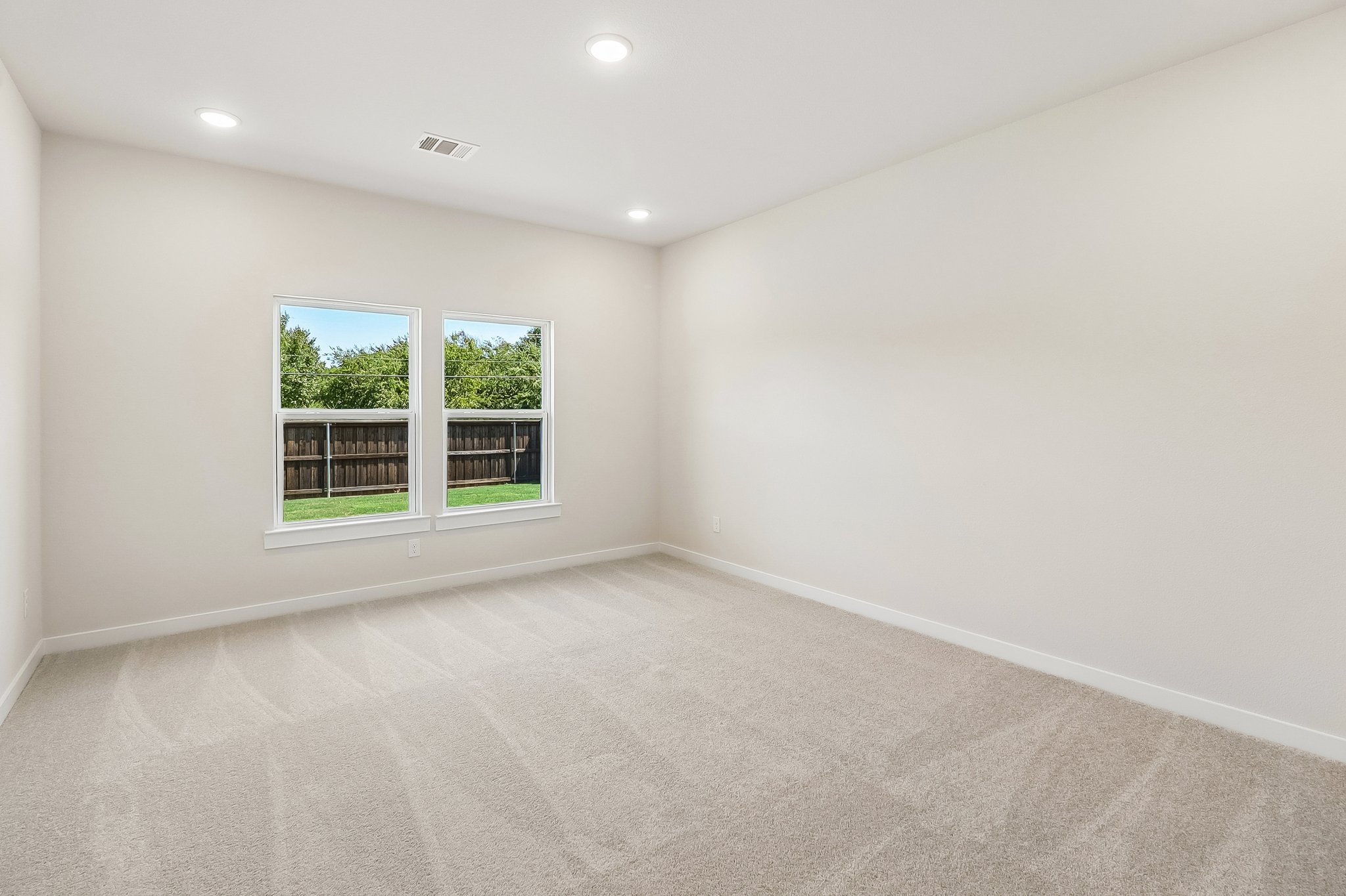 A room with a window and a carpet.