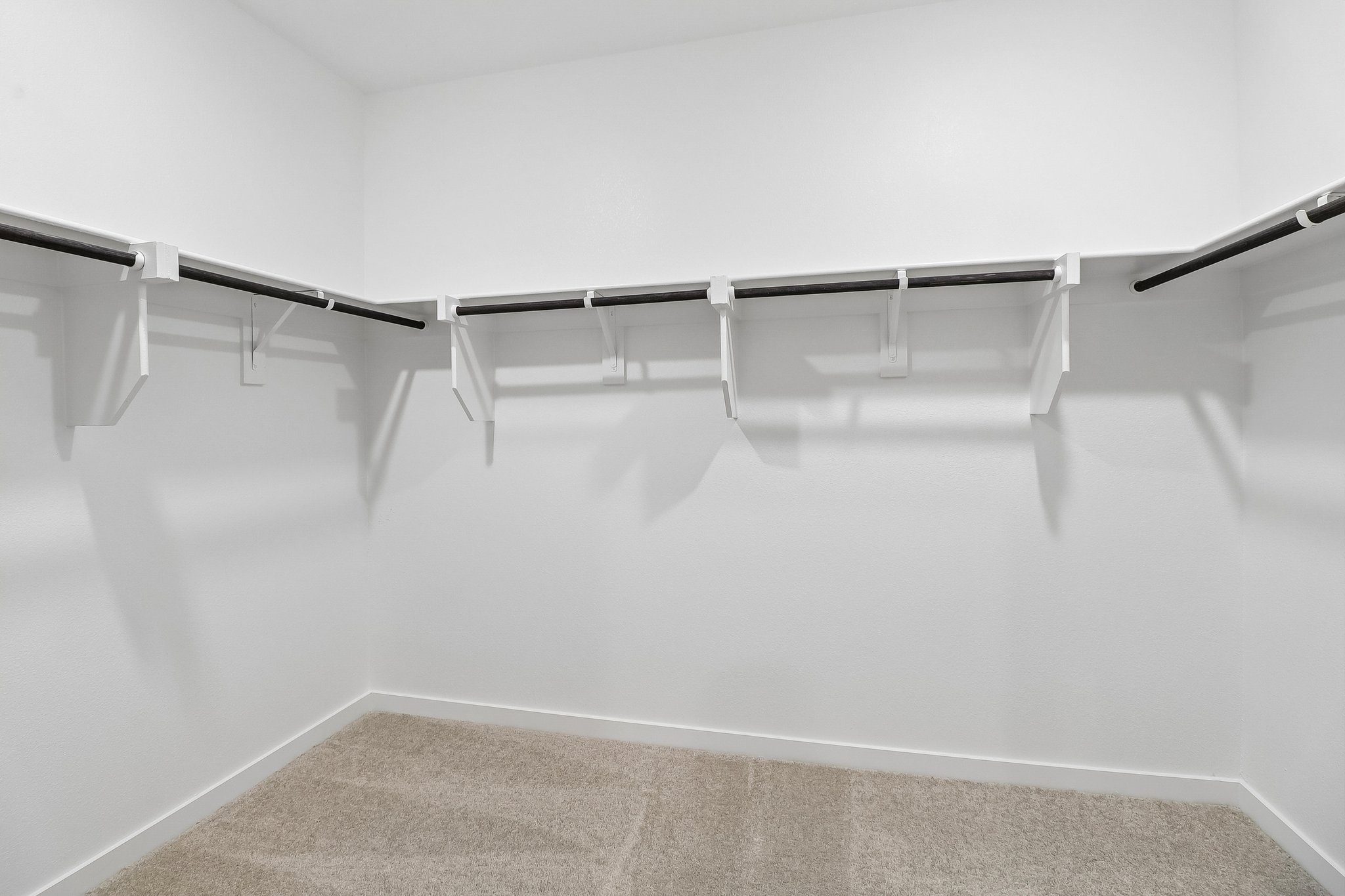 A white wall with a metal bar.