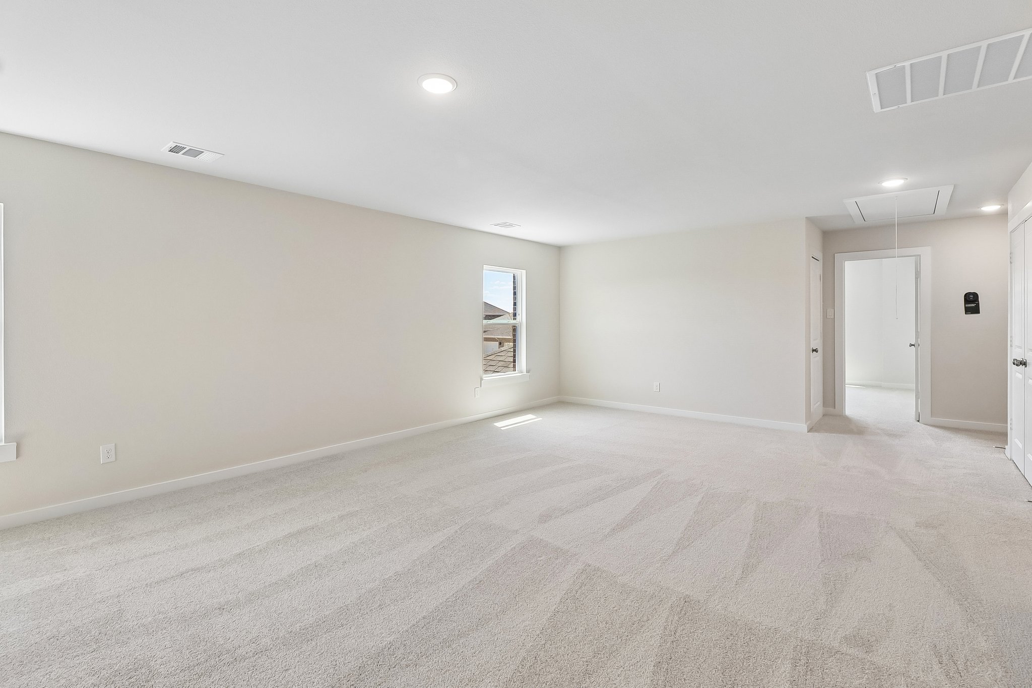 A room with a carpet and a window.