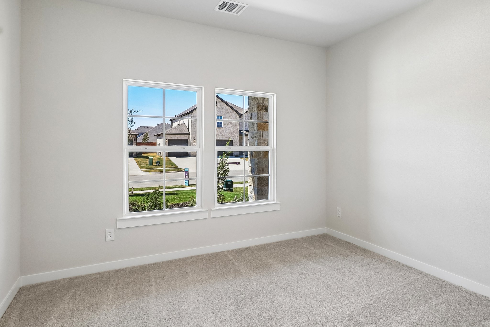 A room with a window and a white wall.