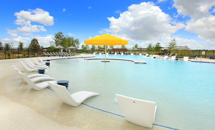 A pool with chairs and umbrella.