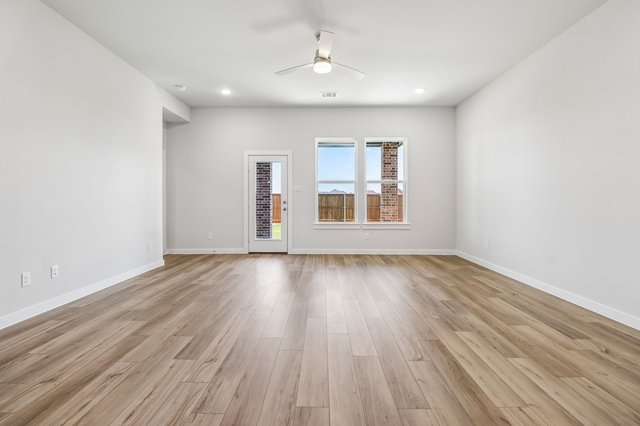 A room with a wood floor and a ceiling fan.