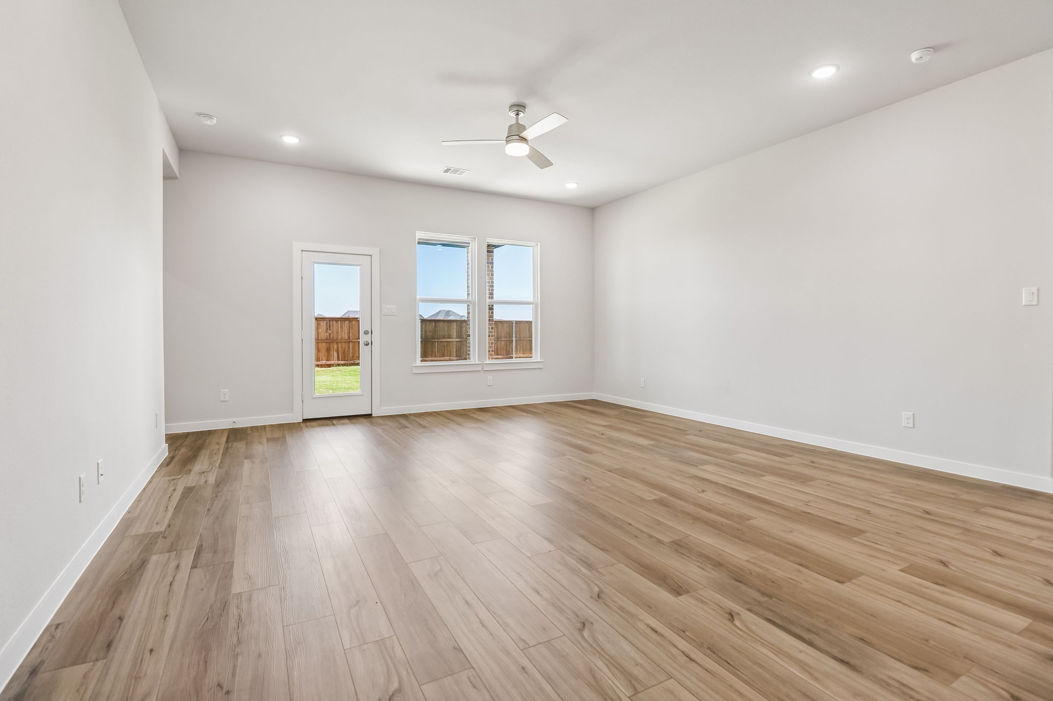 A room with a wood floor and a ceiling fan.