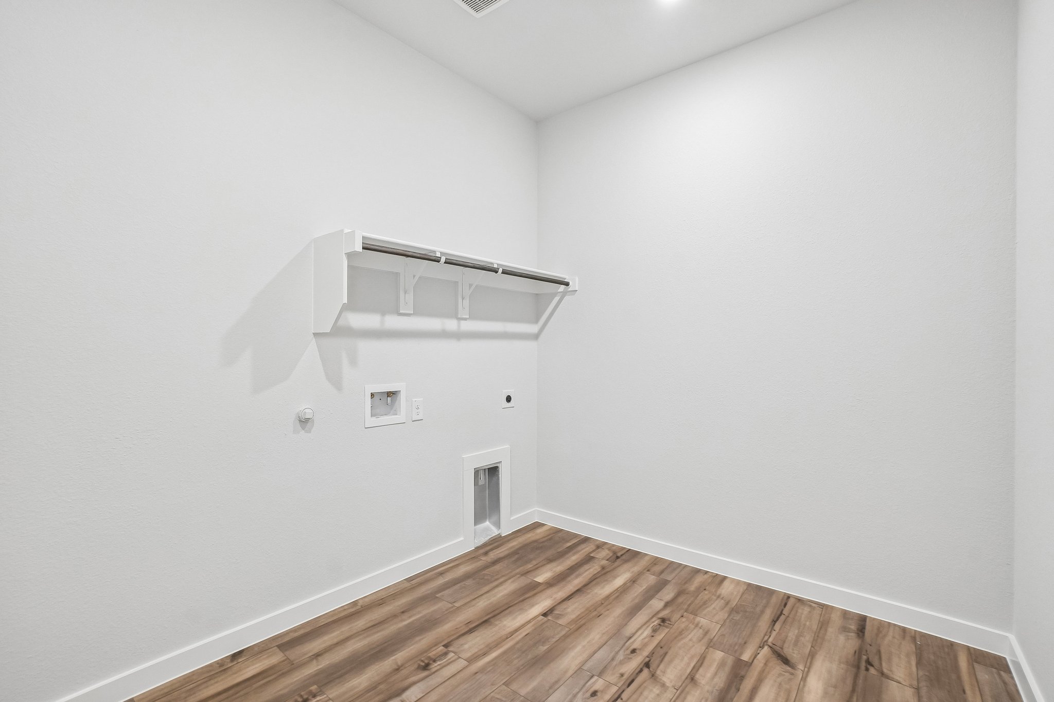 A white room with a wood floor.