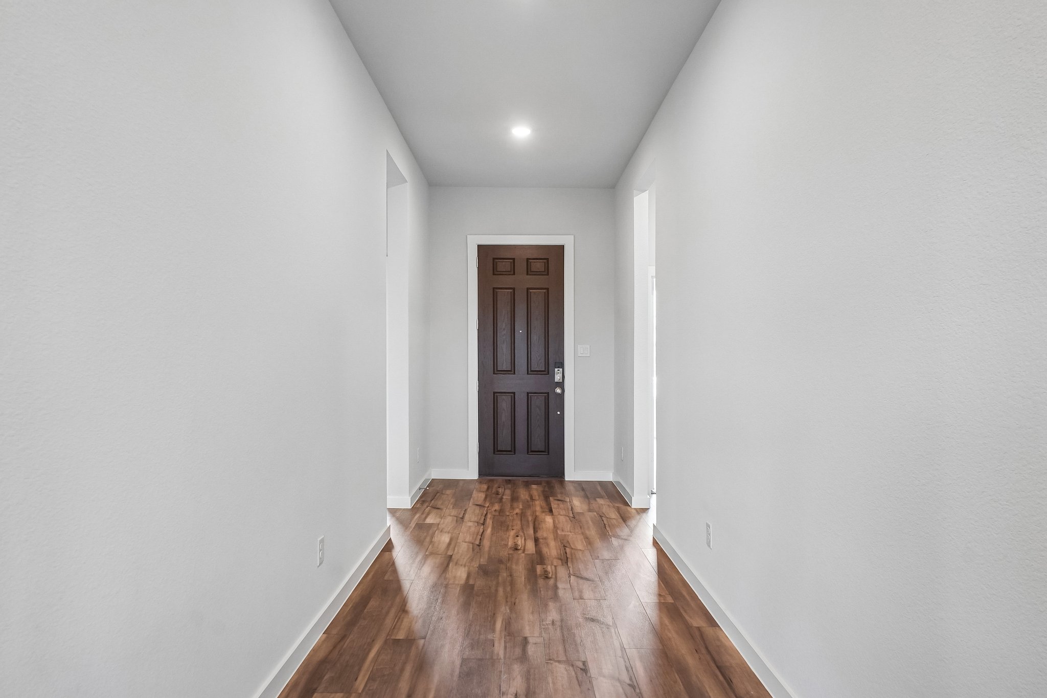 A hallway with a wood floor.