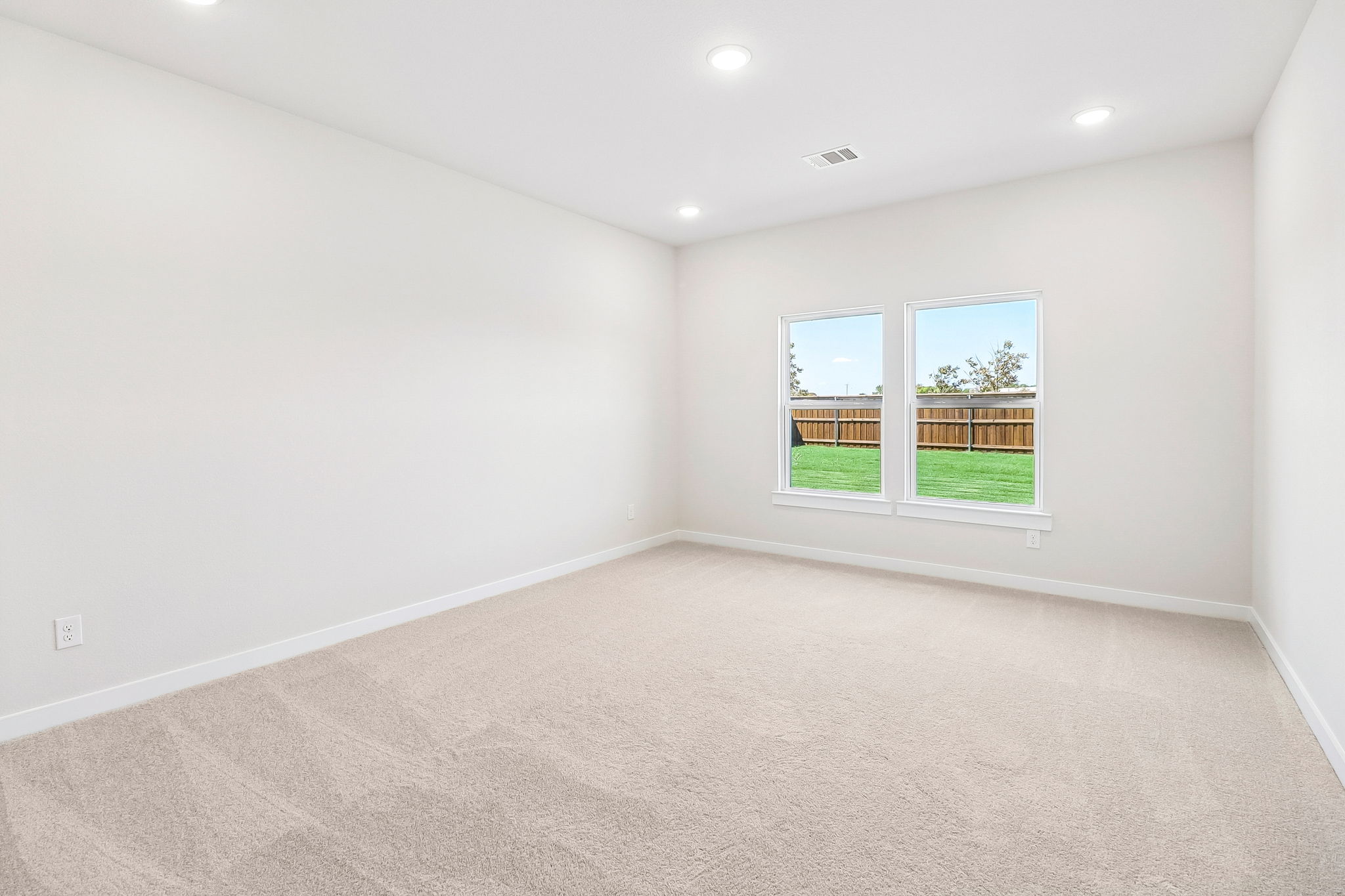 A room with a window and a carpet.
