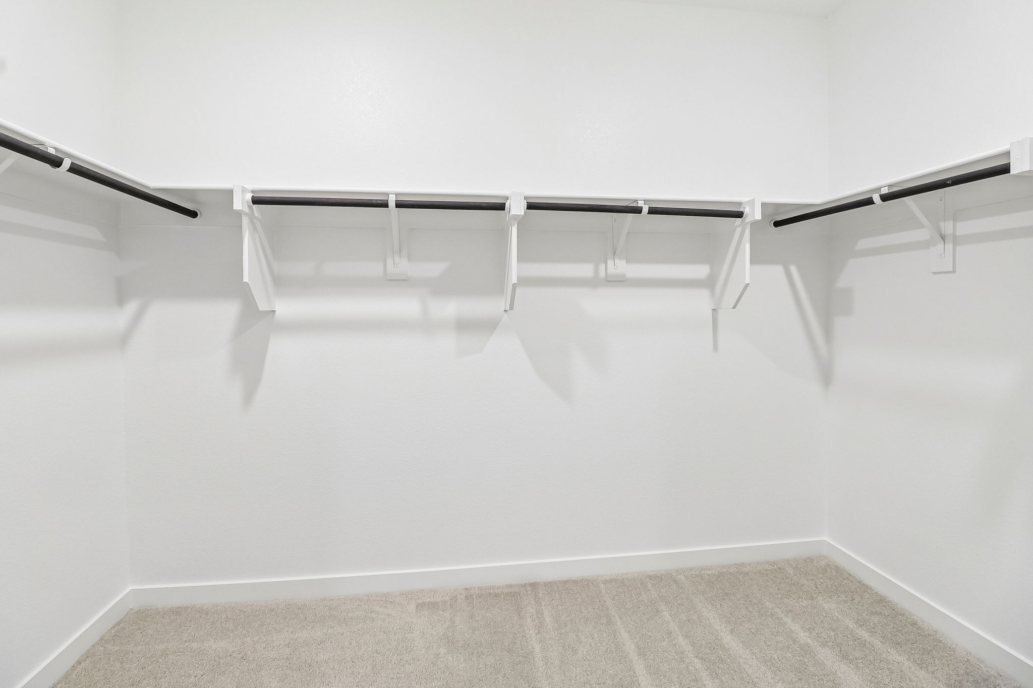 A white wall with a metal bar.