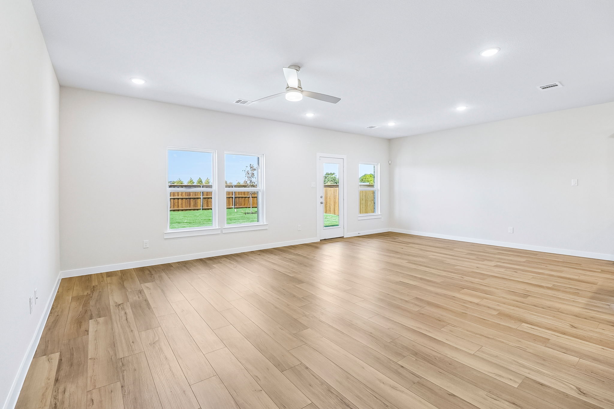 A room with a wood floor and a ceiling fan.