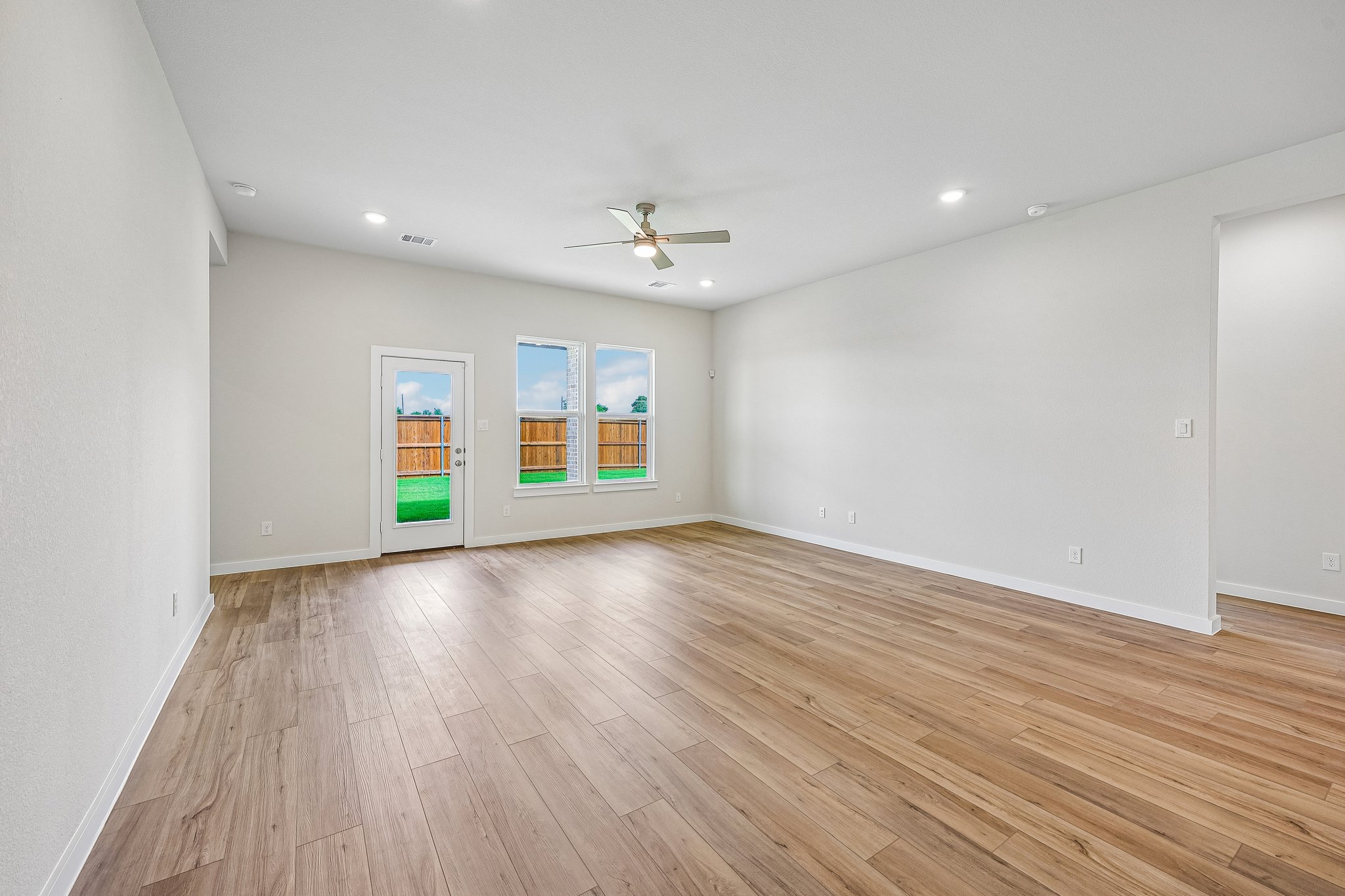 A room with a wood floor and a ceiling fan.