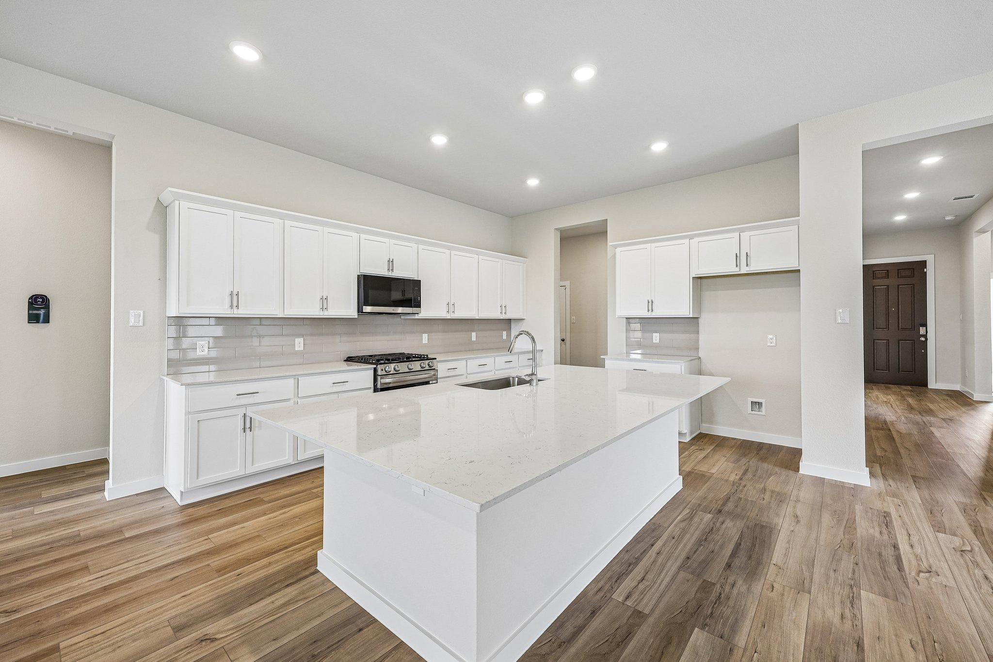 A kitchen with white cabinets.