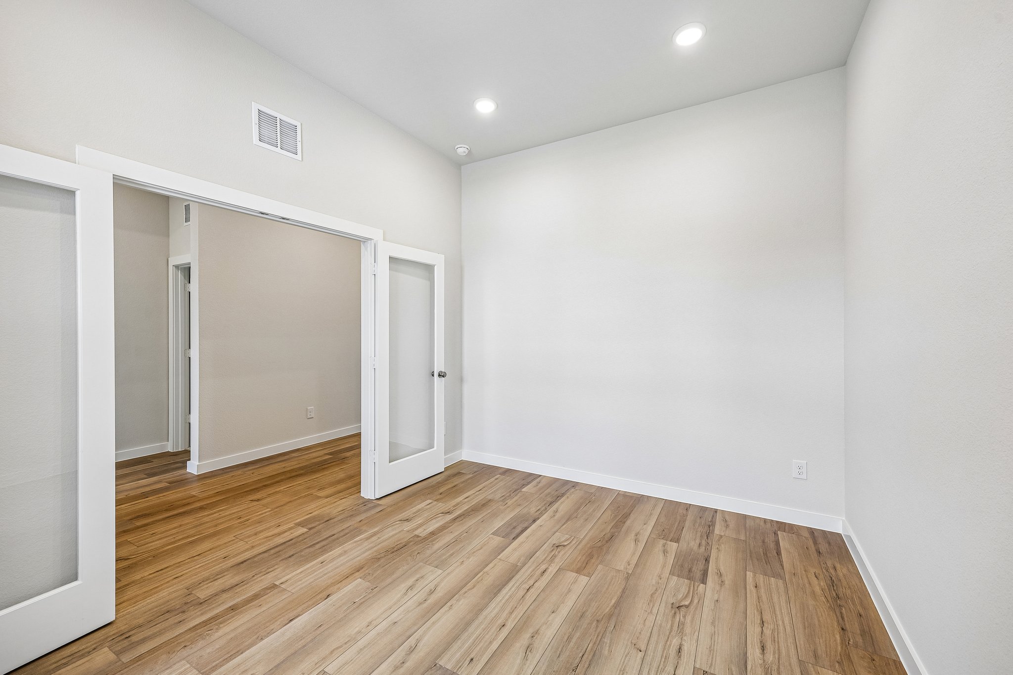 A room with a wood floor and white walls.