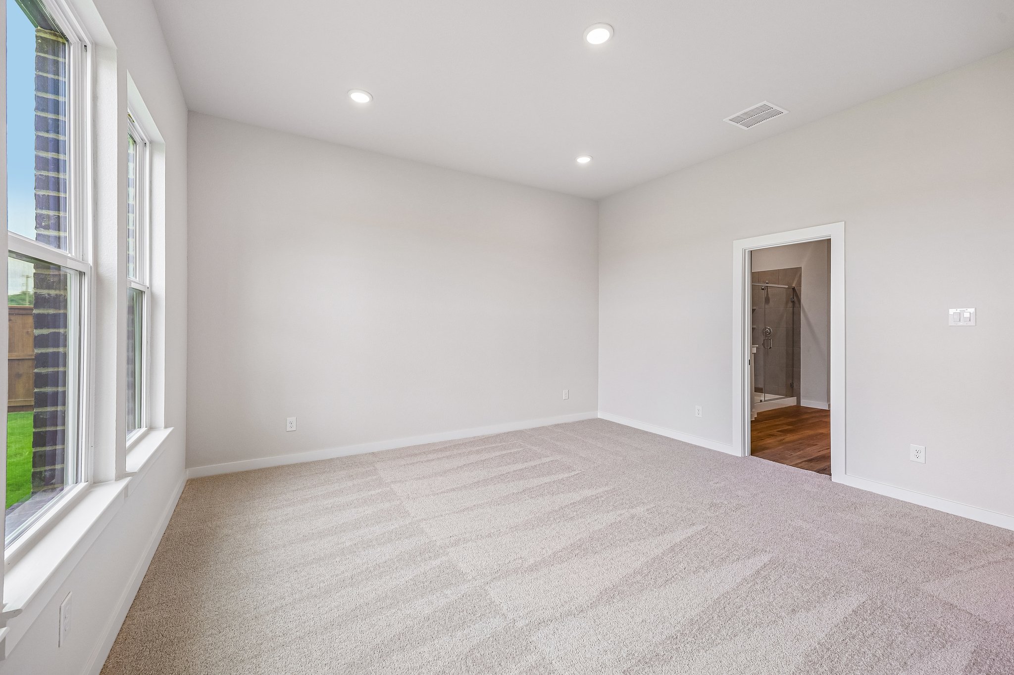 A room with a carpet and windows.