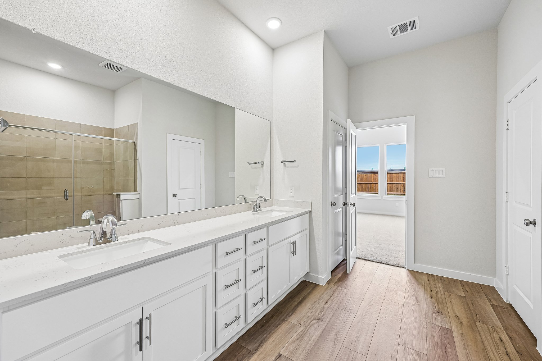 A bathroom with white cabinets.