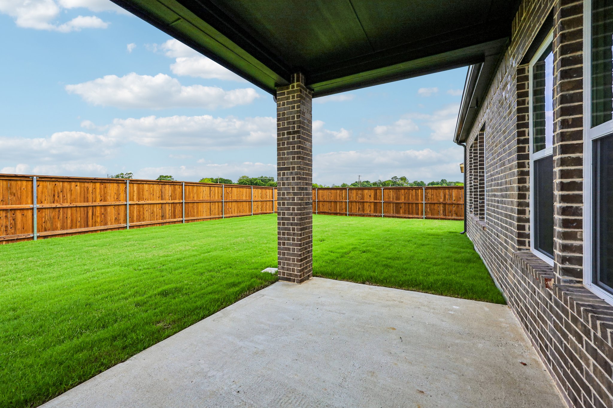 A brick structure in a grassy area.
