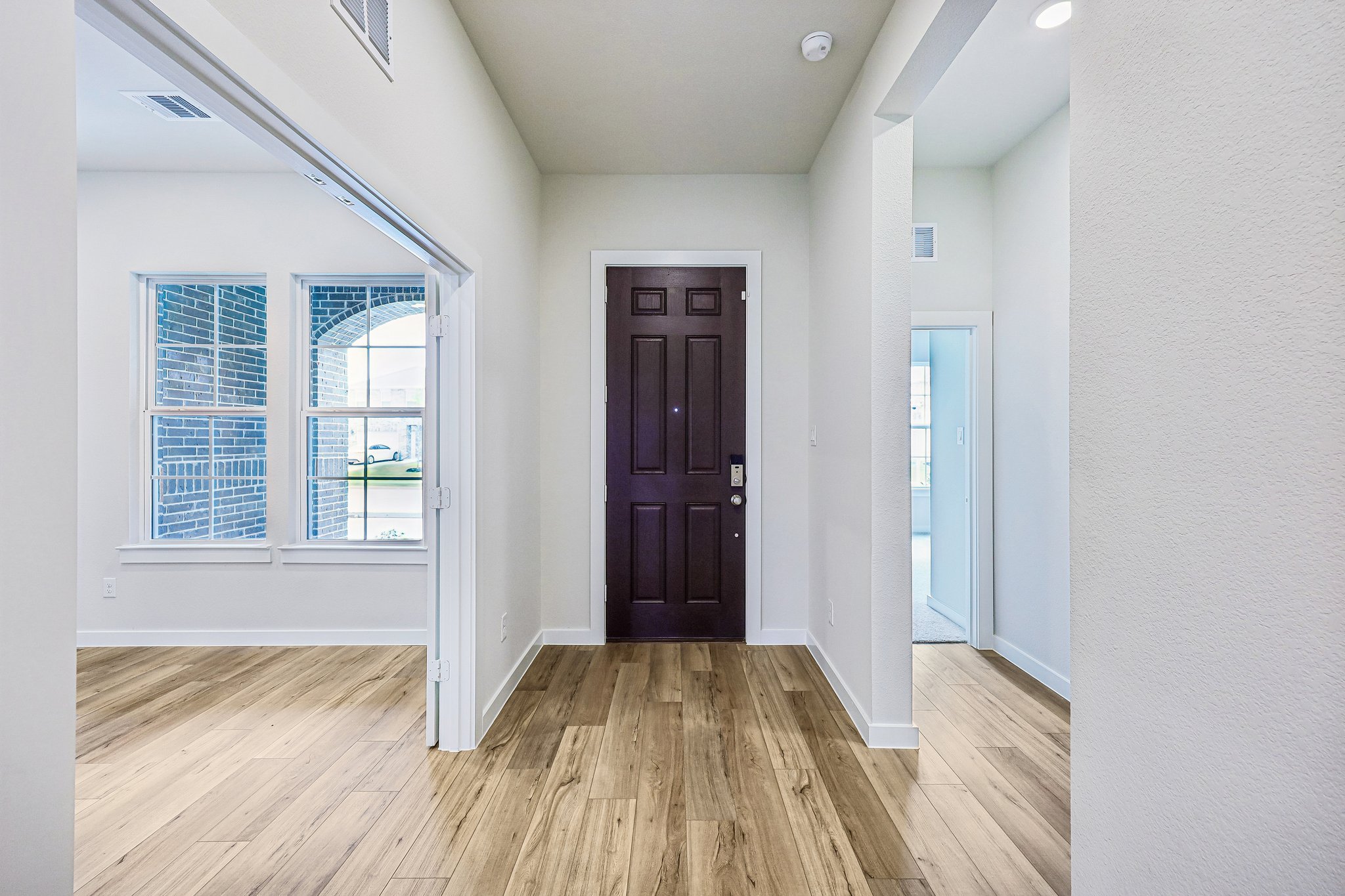 A room with a wood floor and a wood floor with a door.