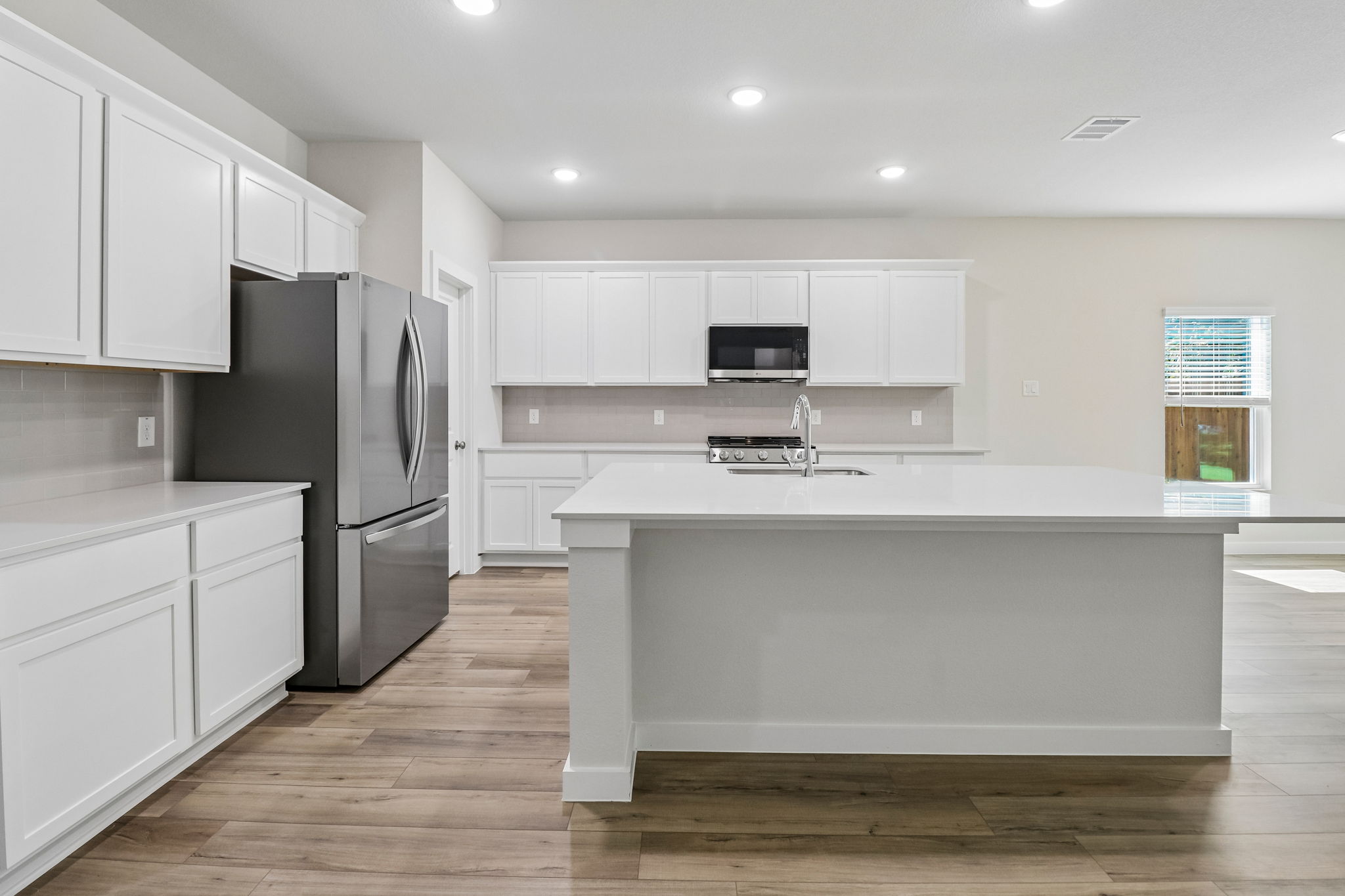 A kitchen with white cabinets.
