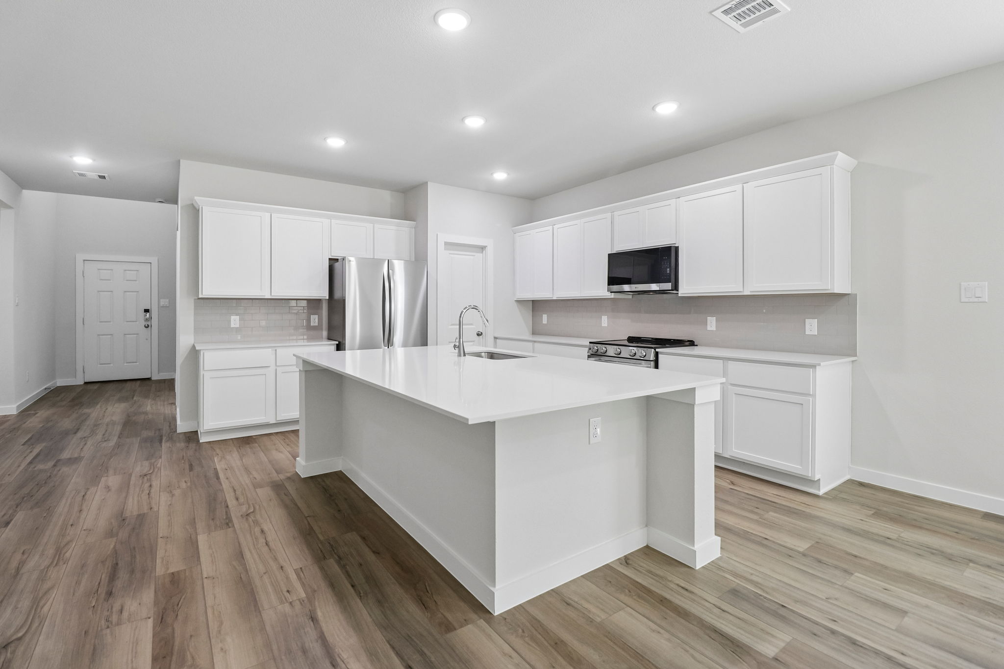 A kitchen with white cabinets.