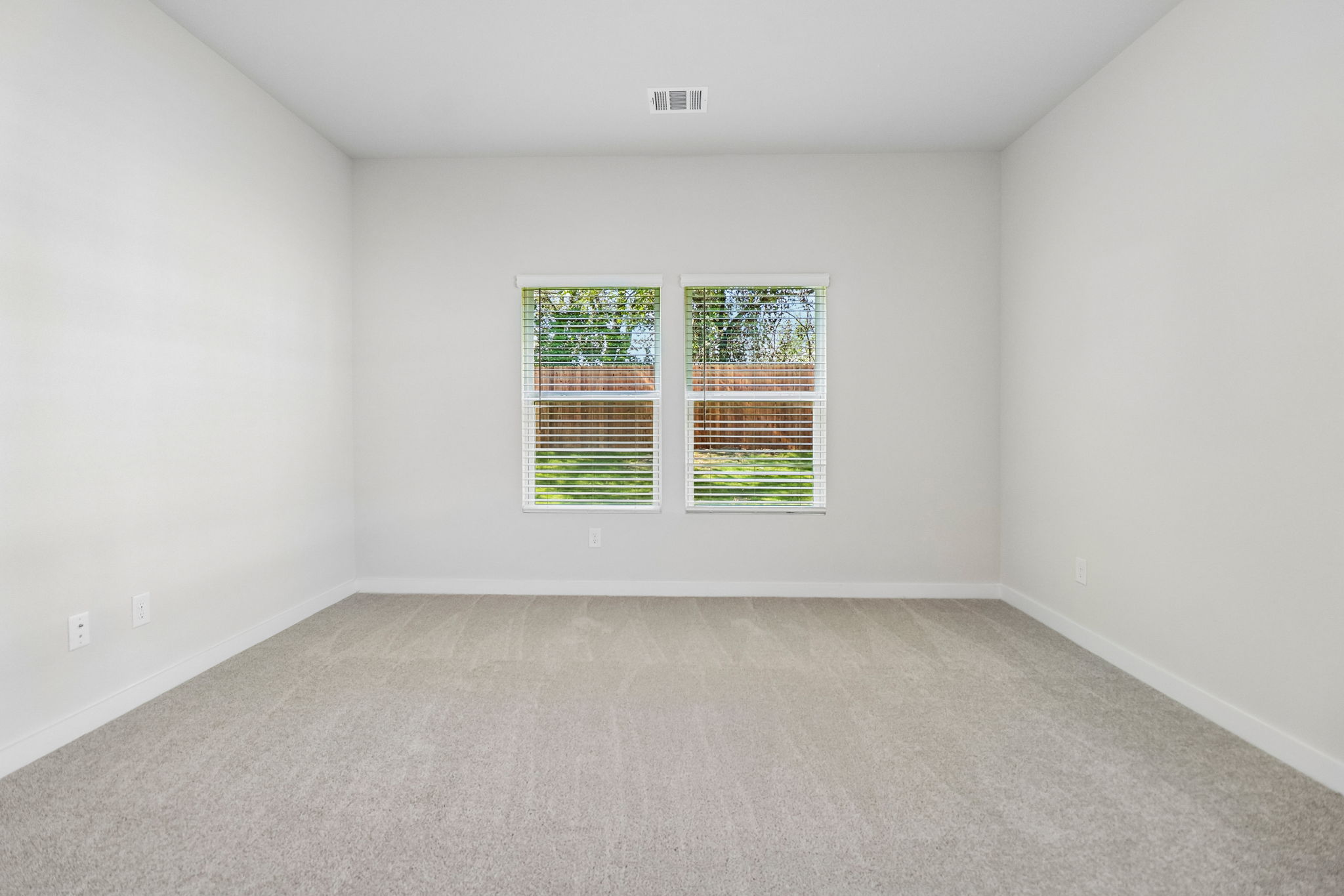 A room with a window and a carpet.
