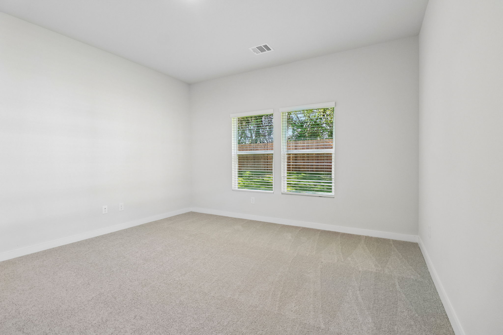 A room with a window and a carpet.