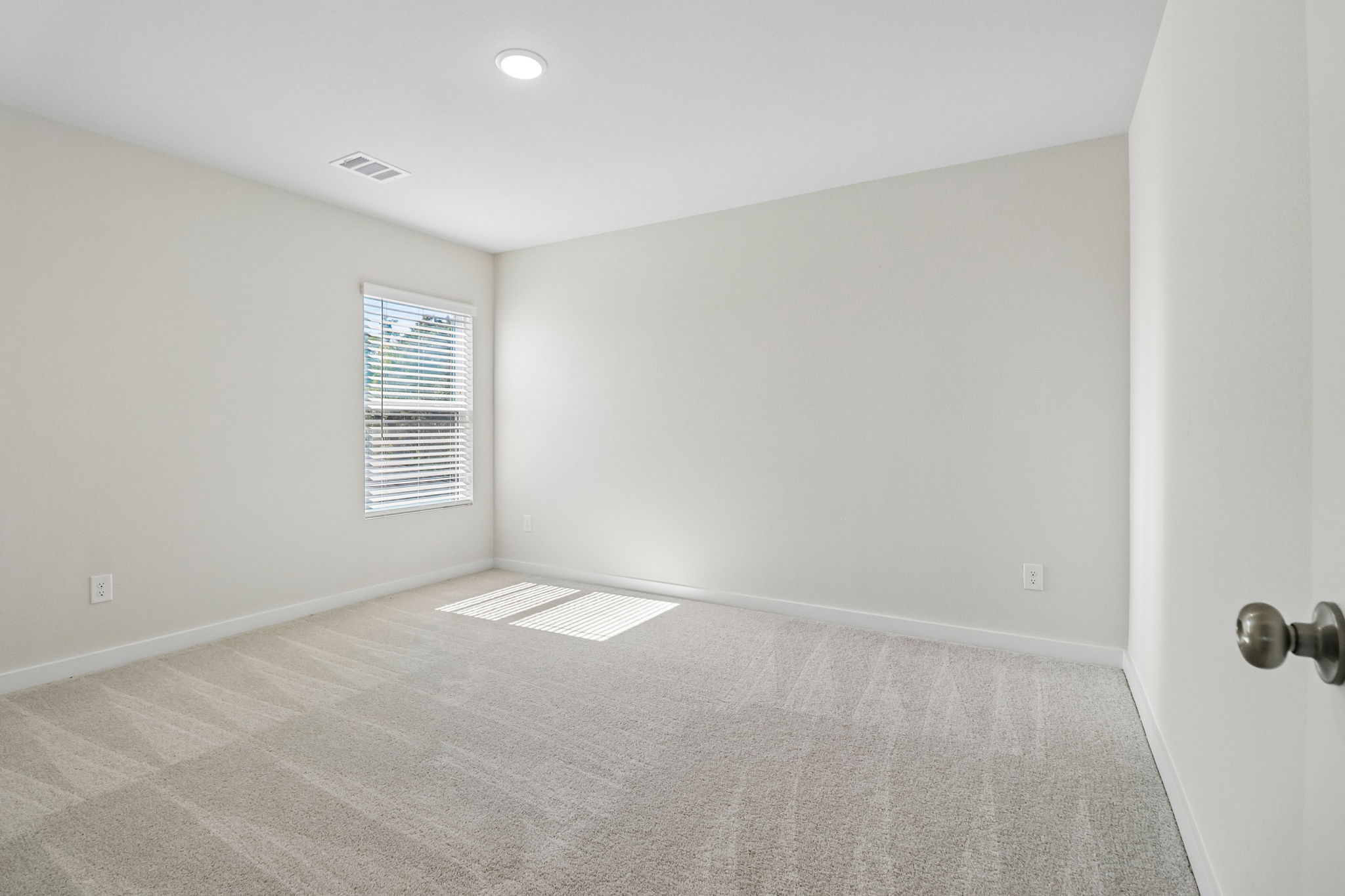 A room with a carpet and a window.