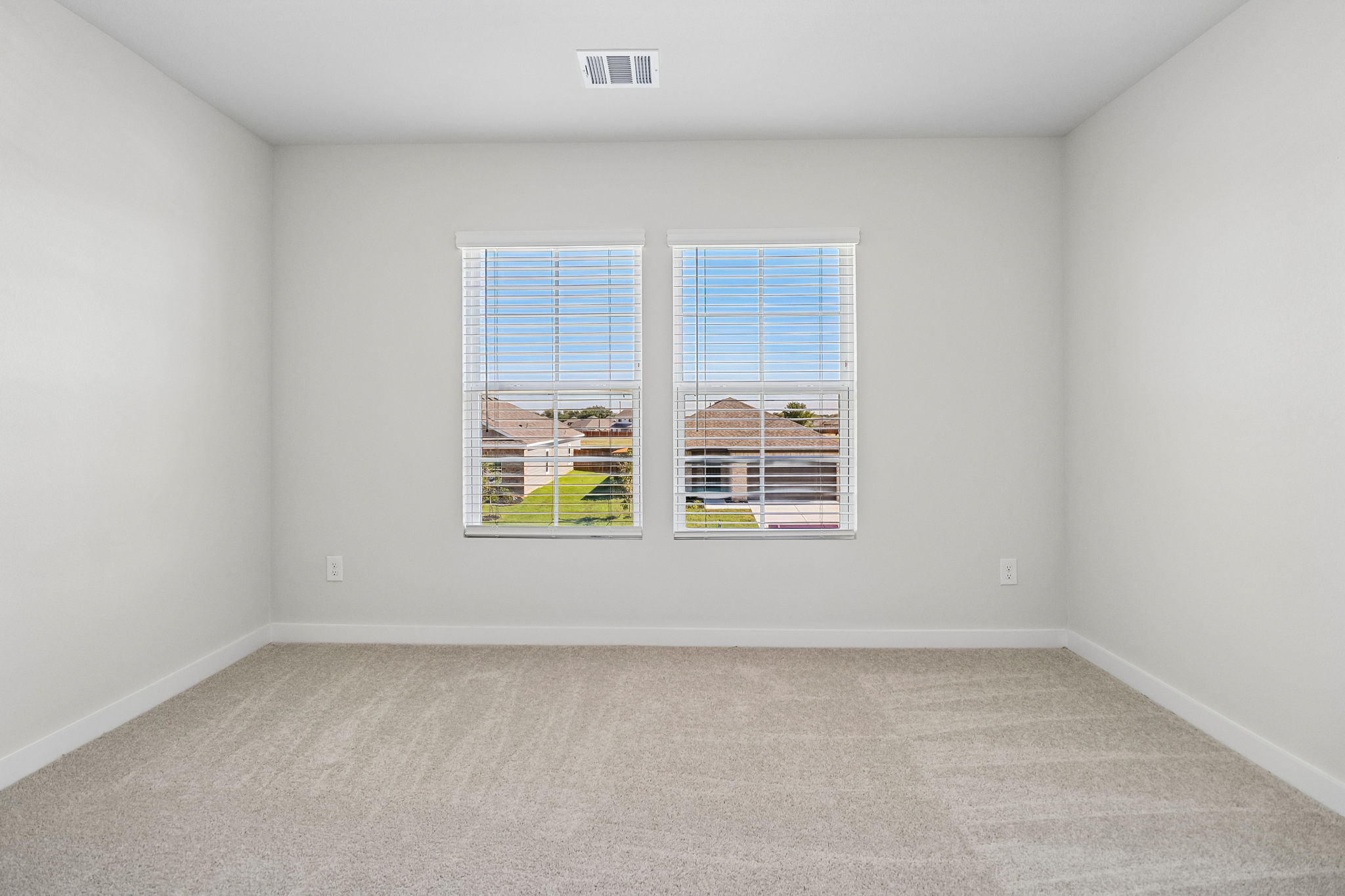 A room with a window and a carpet.