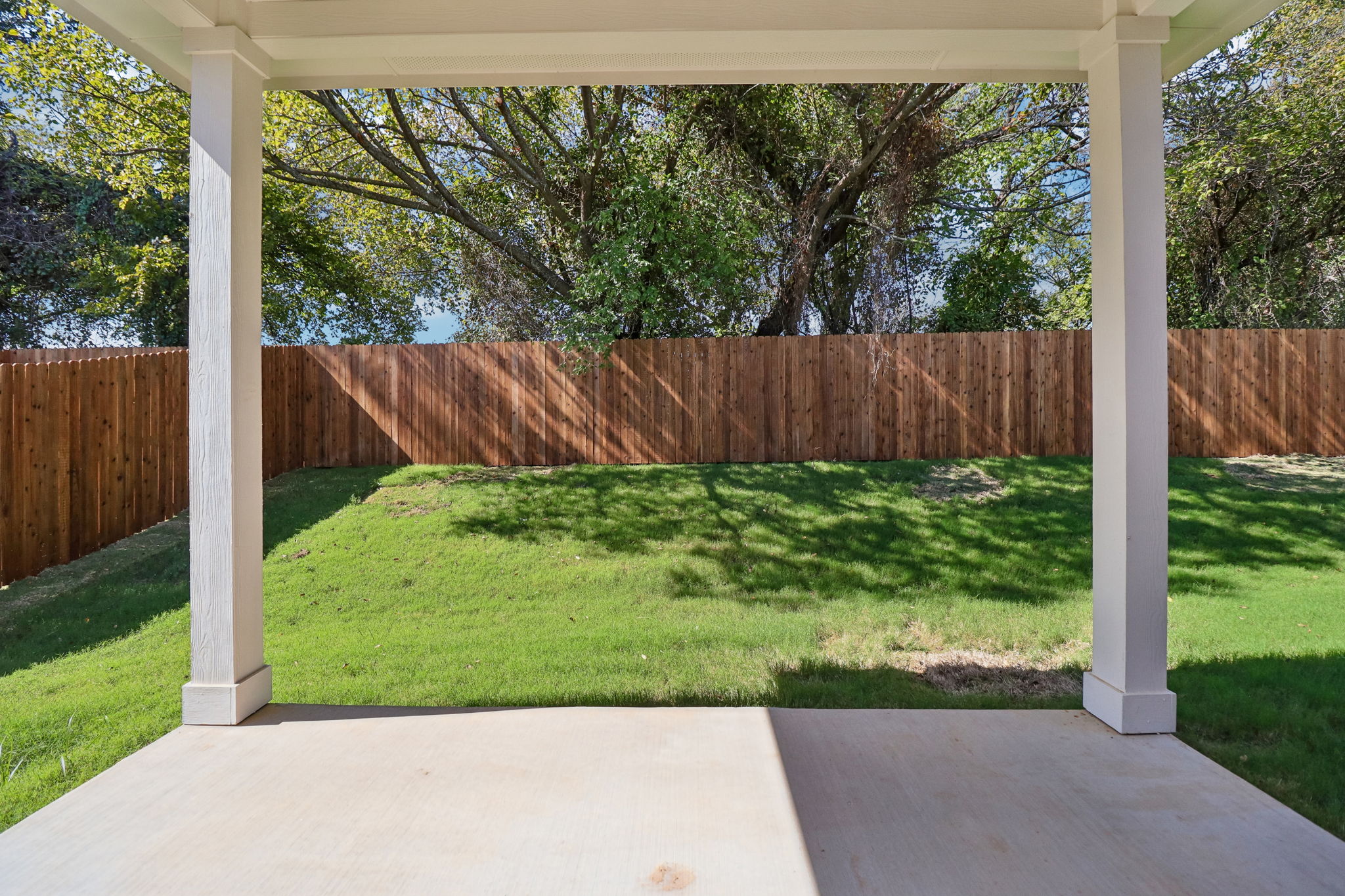 A fenced yard with a wood gate and a wood fence.
